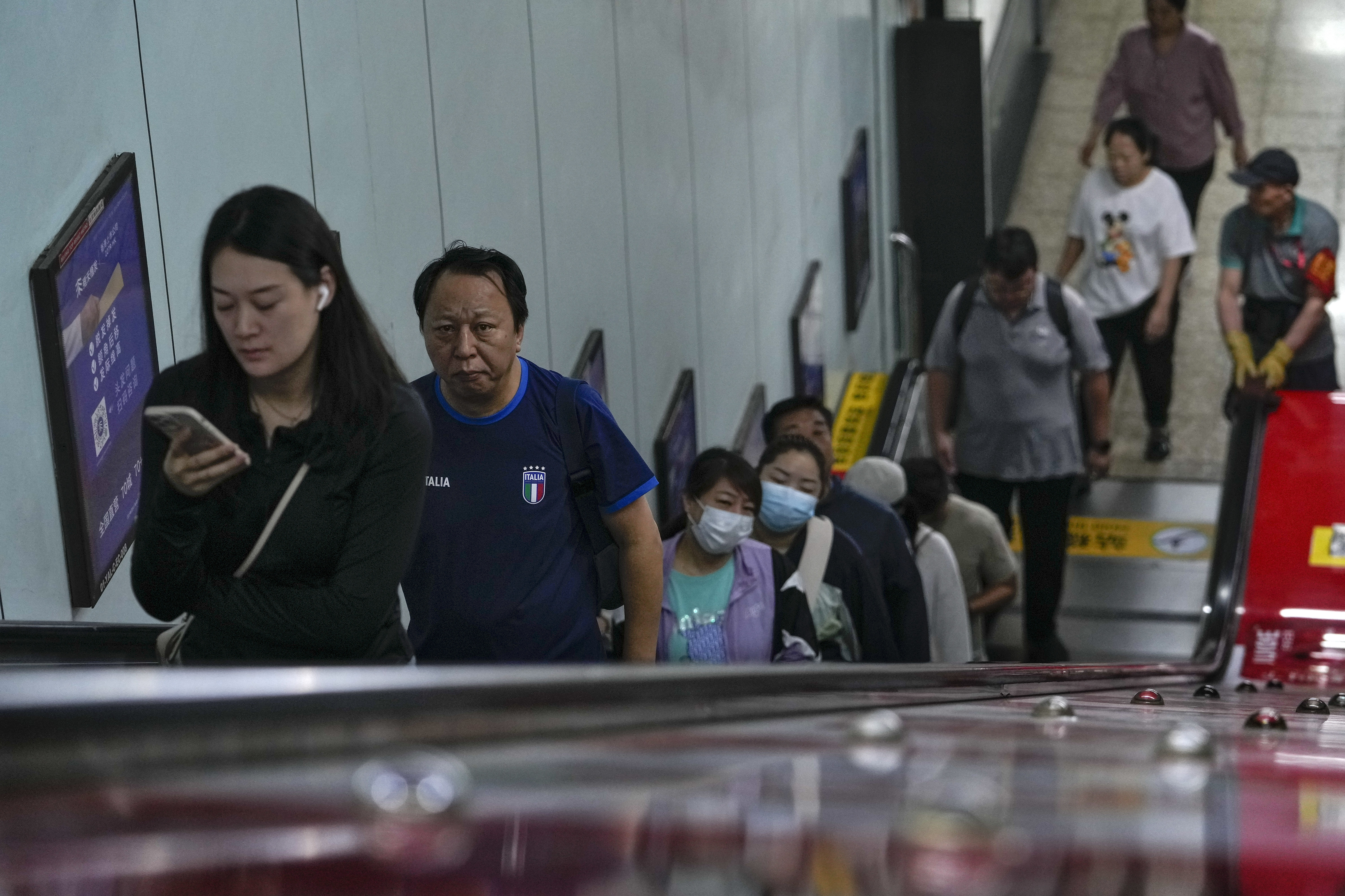 Commuters ride an escalator at a subway station during the morning rush hour in Beijing, Friday, Sept. 13, 2024. (AP Photo/Andy Wong)