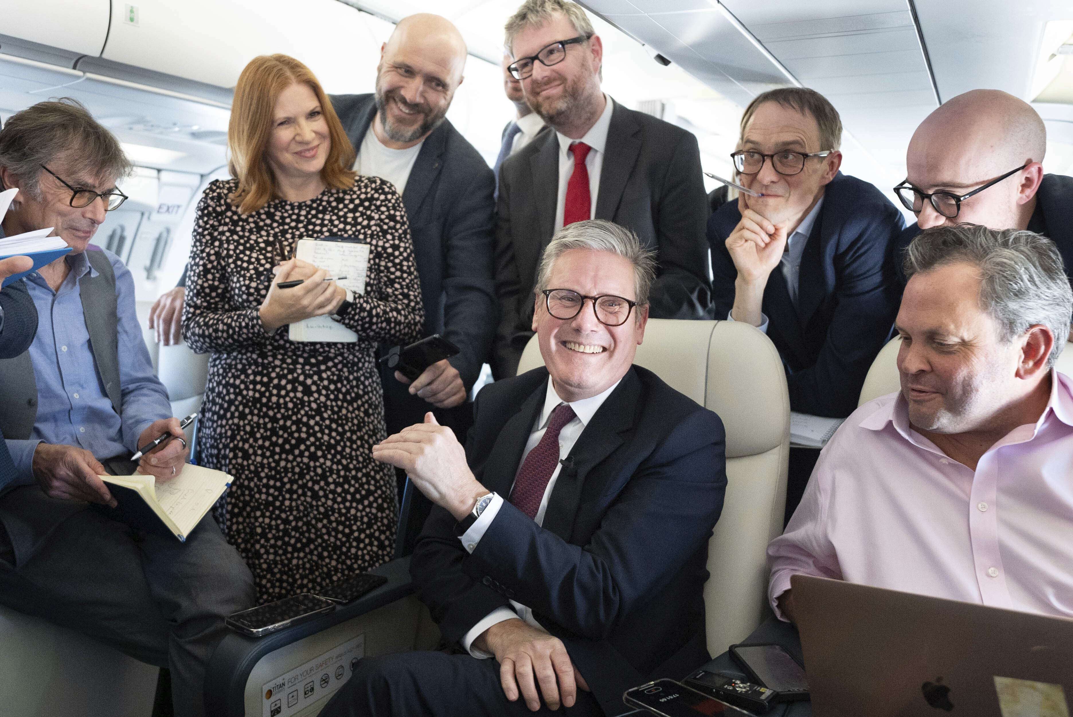 Britain's Prime Minister Keir Starmer, center, talks to the media on board his plane as he flies to Washington DC., Thursday Sept. 12, 2024. (Stefan Rousseau/Pool via AP)