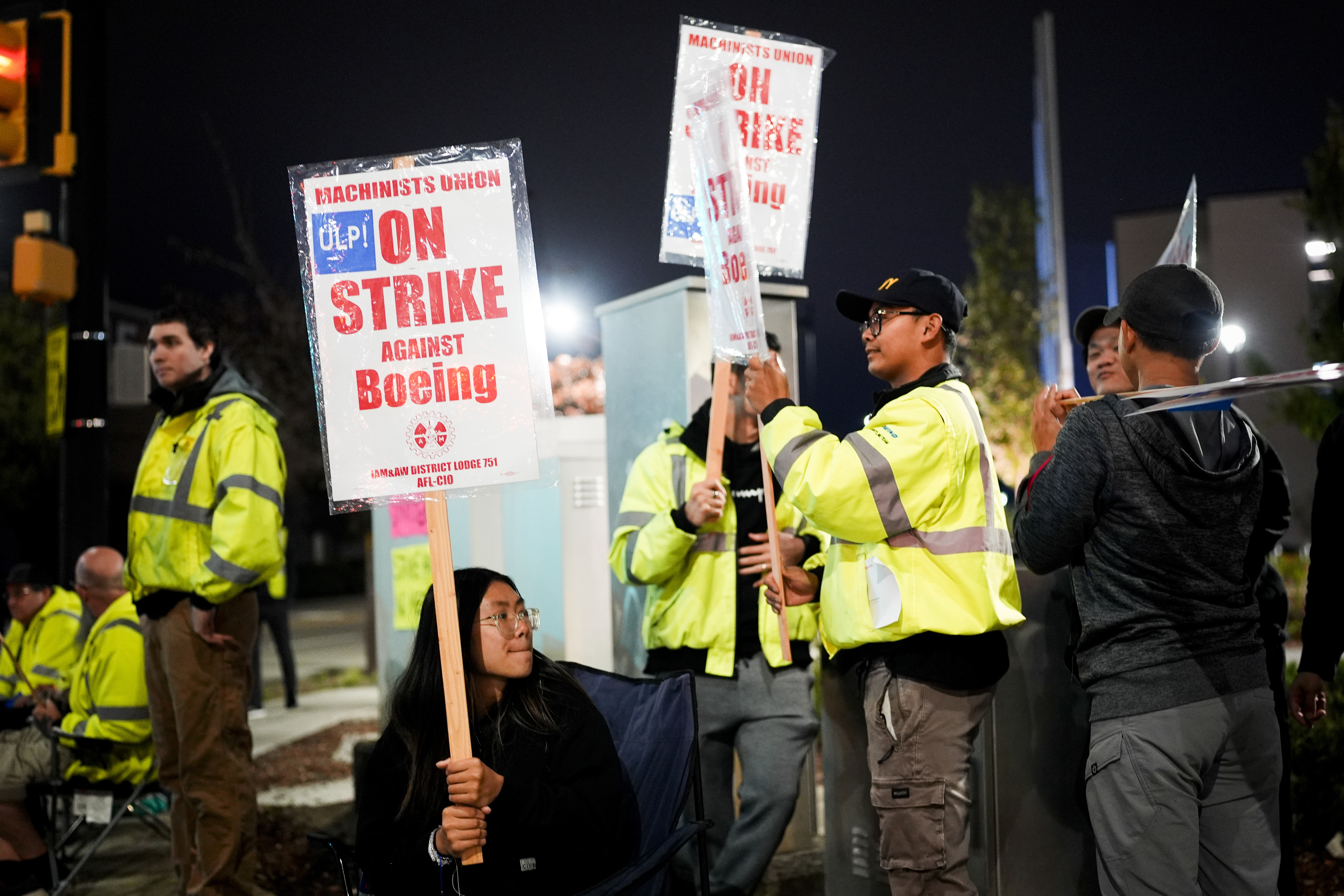 Boeing employee Dianna Vu, 20, a grade 6 mechanic, holds a picket sign with coworkers after union members voted overwhelmingly to reject a contract offer and go on strike Friday, Sept. 13, 2024, outside the company's factory in Renton, Wash. (AP Photo/Lindsey Wasson)