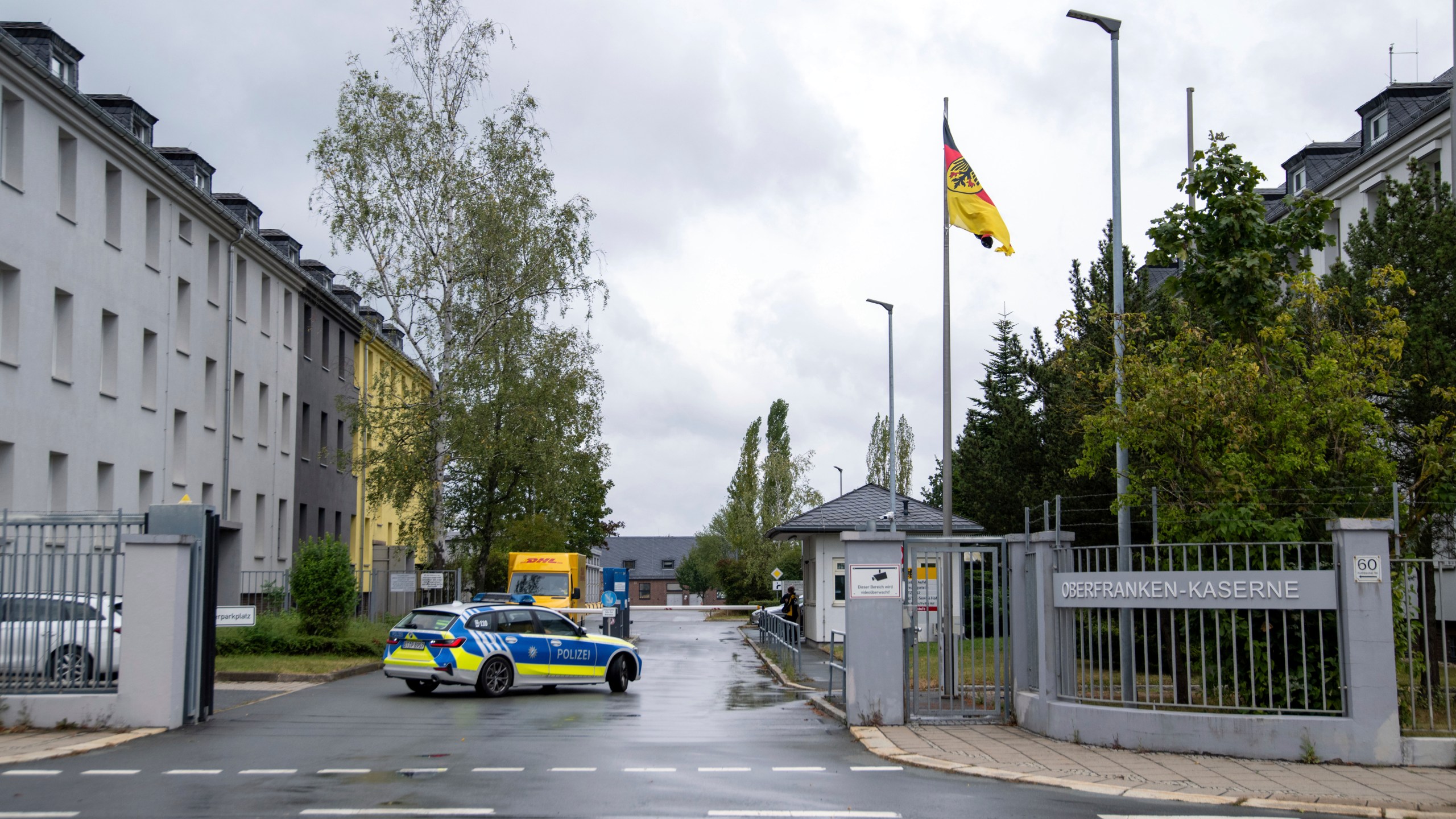 A police car drives on the grounds of the Upper Franconia barracks, in Hof, Germany. Investigators in Bavaria have arrested a 27-year-old Syrian man for planning to attack Bundeswehr soldiers in Upper Franconia. (Pia Bayer/dpa via AP)