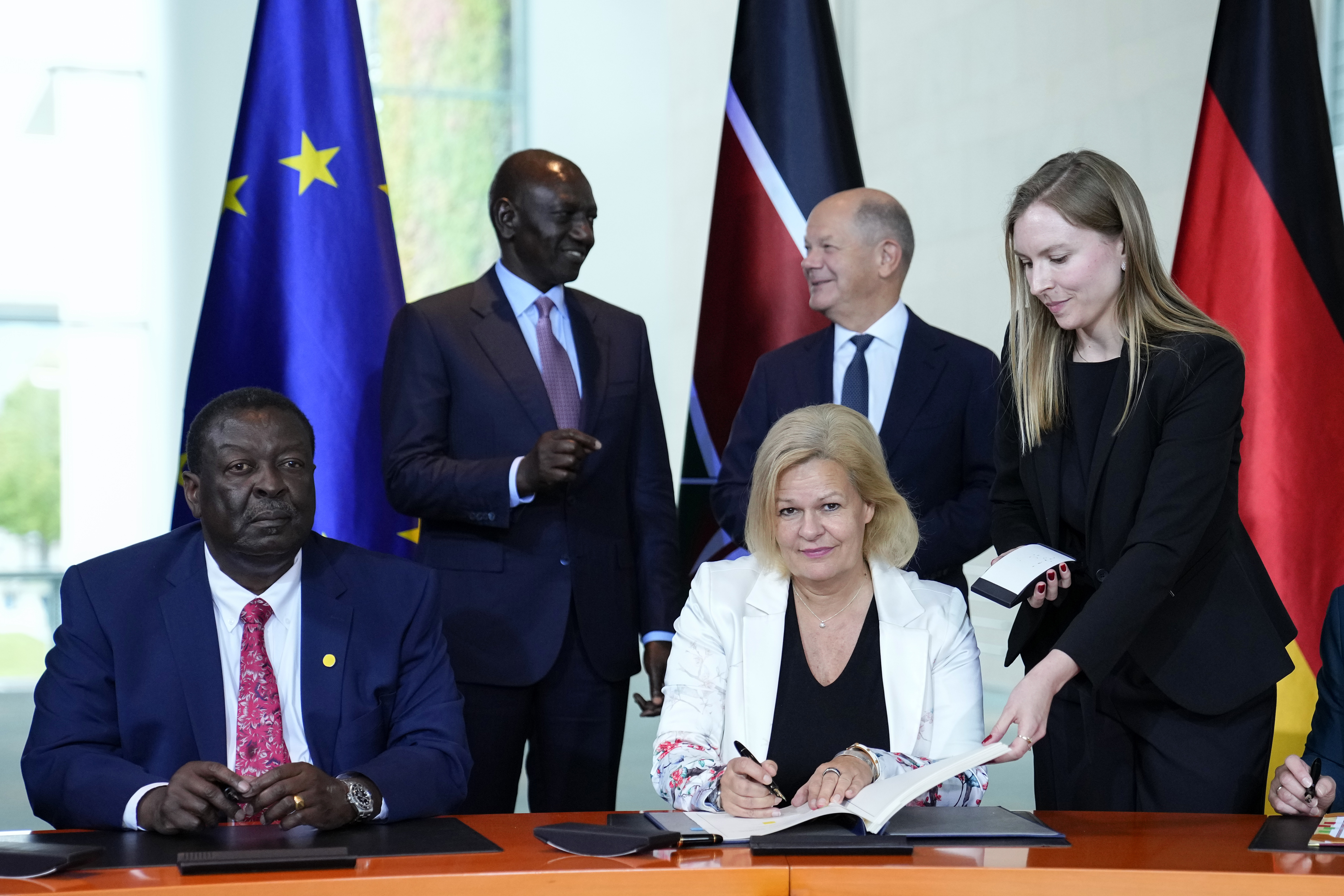 German Interior Minister Nancy Faeser, down right, signs a migration agreement with Kenyan's Prime Cabinet Secretary Musalia Mudavadi, left, as German Chancellor Olaf Scholz, centre behind, and Kenyan President William Ruto, left behind, at the chancellery in Berlin, Friday, Sept. 13, 2024. (AP Photo/Ebrahim Noroozi)