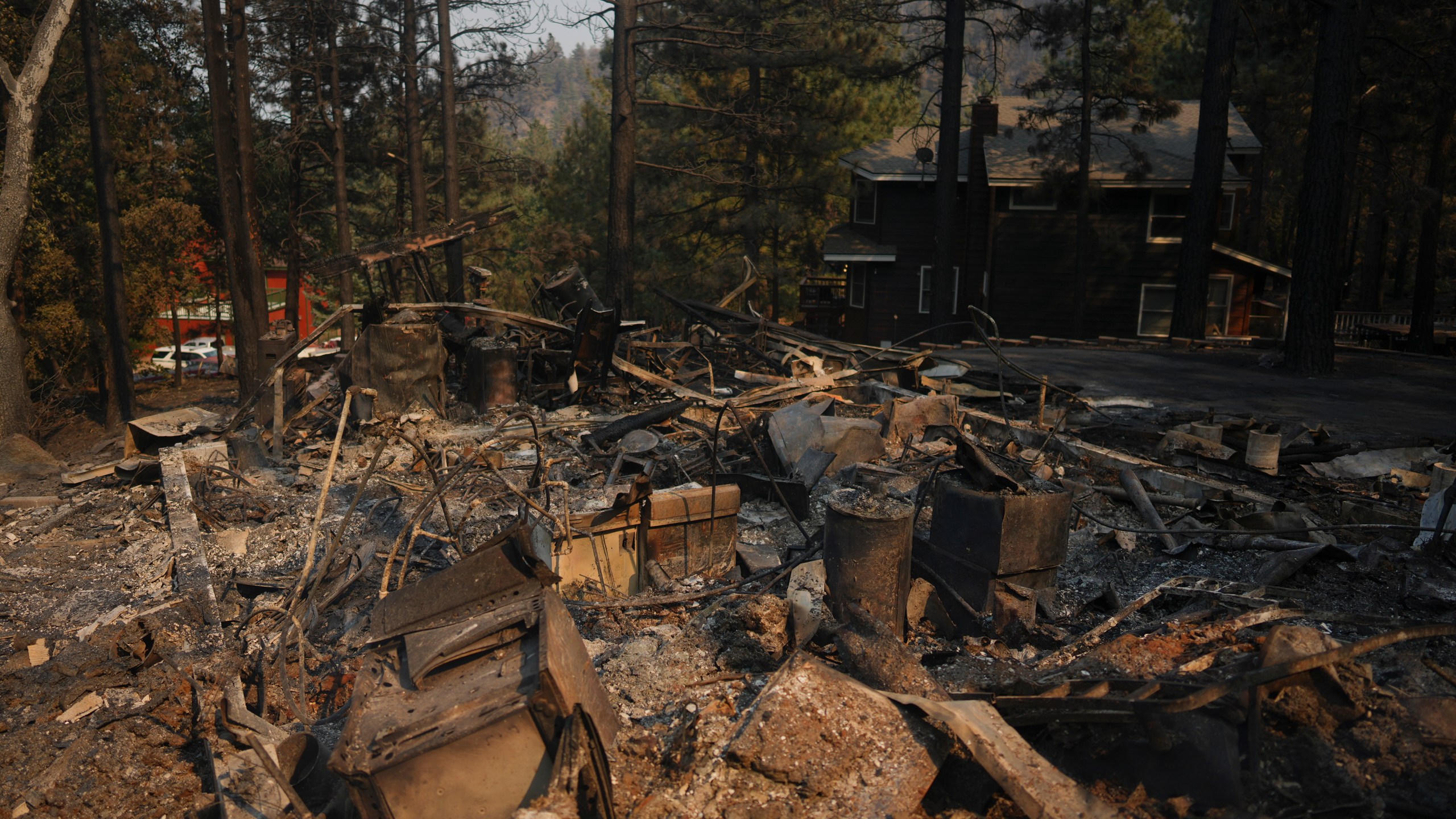 A fire-ravaged property is seen after the Bridge Fire swept through, Thursday, Sept. 12, 2024, in Wrightwood, Calif. (AP Photo/Eric Thayer)