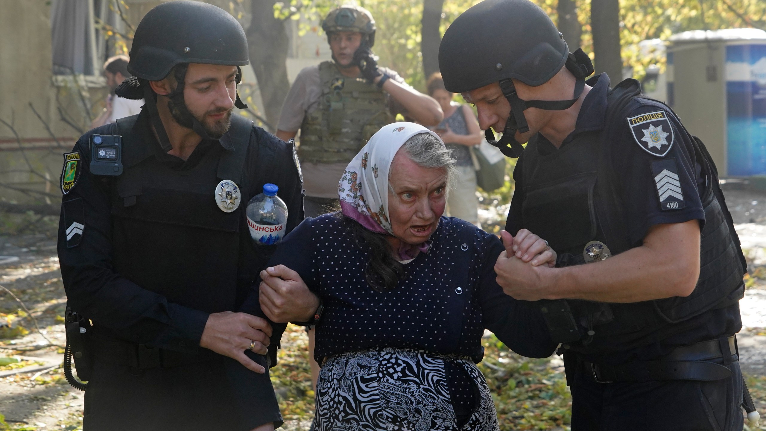 An elderly woman is assisted after a Russian aerial bomb struck a multi-story residential building in Kharkiv, Ukraine, Sunday Sept. 15, 2024. (AP Photo/Andrii Marienko)