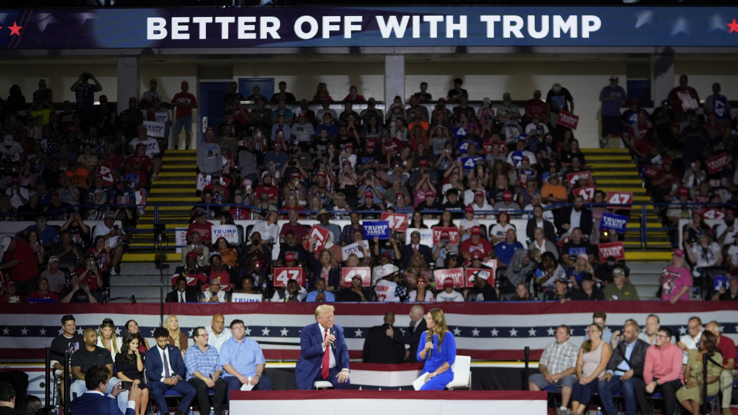 Republican presidential candidate former President Donald Trump, left, on stage with Arkansas Gov. Sarah Huckabee Sanders, right, during a town hall event at the Dort Financial Center, Tuesday, Sept. 17, 2024, in Flint, Mich. (AP Photo/Paul Sancya)