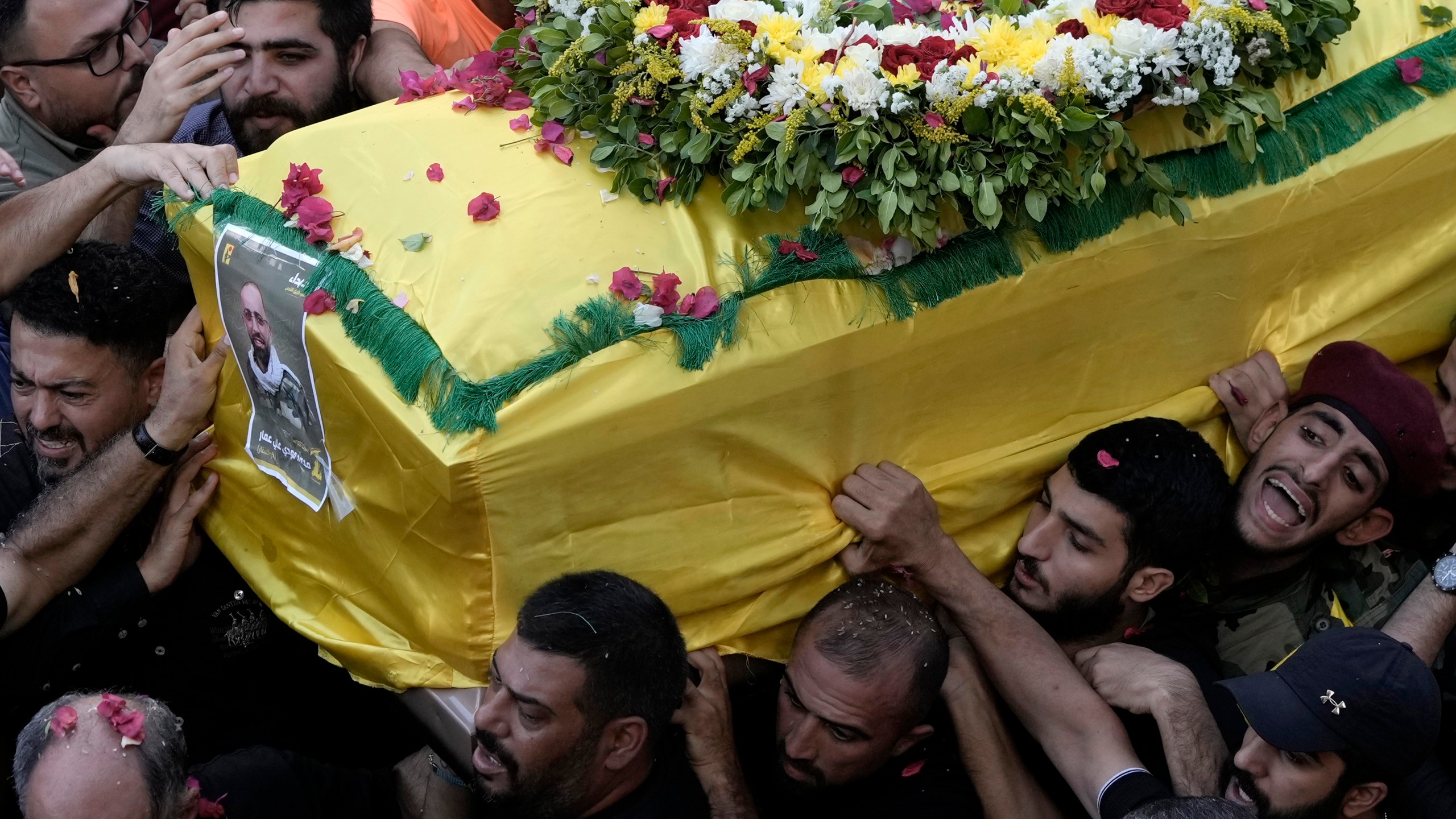 Hezbollah fighters carry one of the coffins of four fallen comrades who were killed Tuesday after their handheld pagers exploded, in the southern suburb of Beirut, Lebanon, Wednesday, Sept. 18, 2024. (AP Photo/Bilal Hussein)