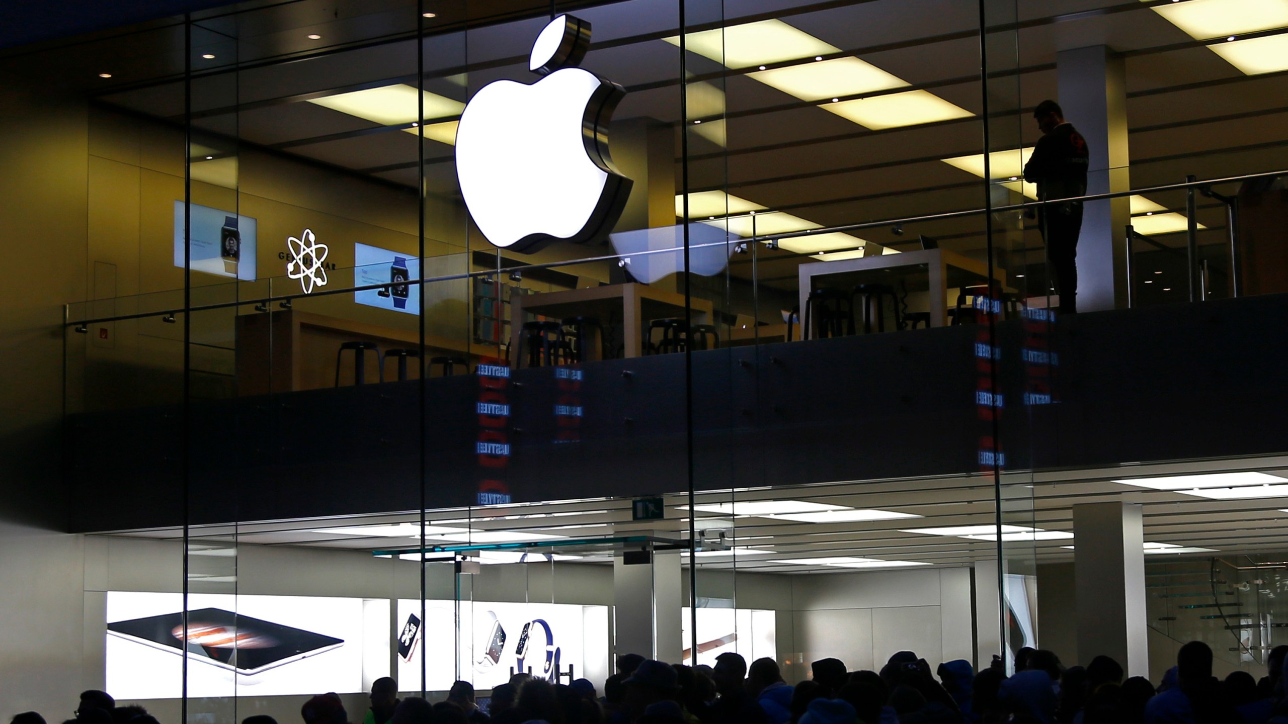 FILE - People wait in front of the Apple store in Munich, Germany, on Sept. 25, 2015. The European Union’s top court has rejected Apple’s final legal challenge against an order from the bloc’s executive commission to repay 13 billion euros in back taxes to Ireland, bringing an end to the long-running dispute (AP Photo/Matthias Schrader, File)