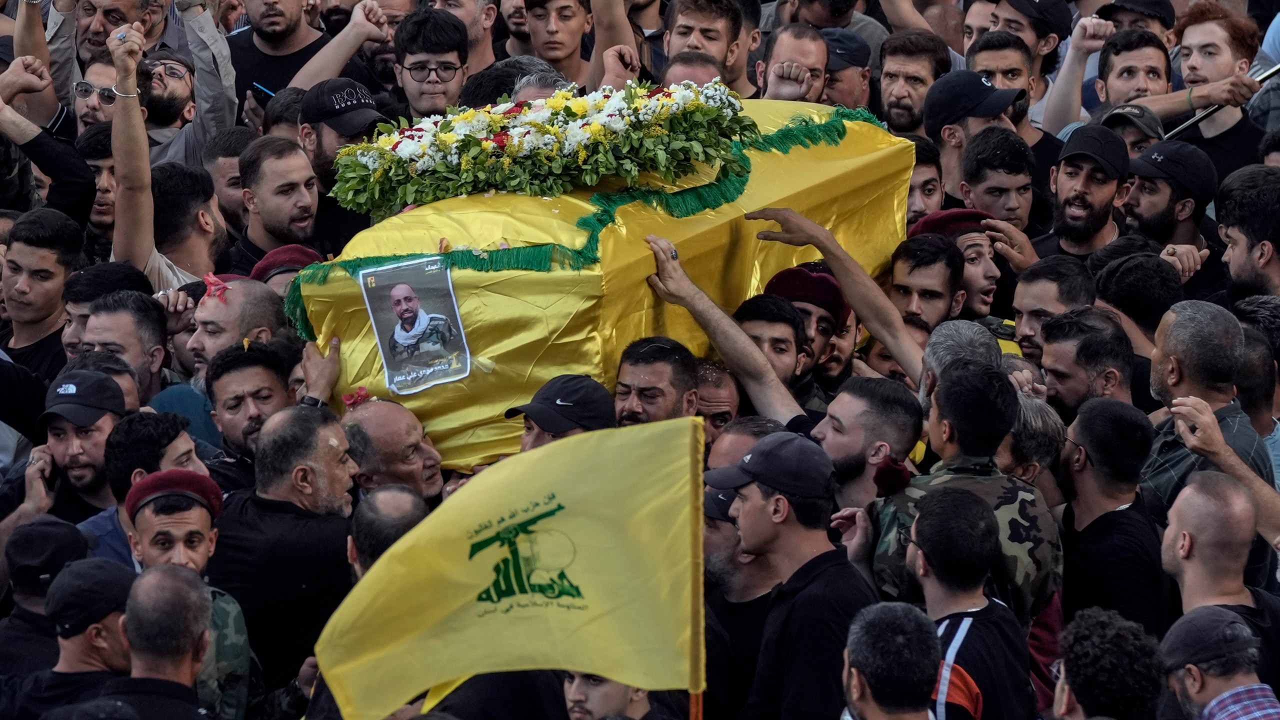 Mourners carry the coffin of Mohammed Mahdi, son of Hezbollah legislator Ali Ammar, who was killed Tuesday after his handheld pager exploded, in the southern suburb of Beirut, Lebanon, Wednesday, Sept. 18, 2024. (AP Photo/Bilal Hussein)