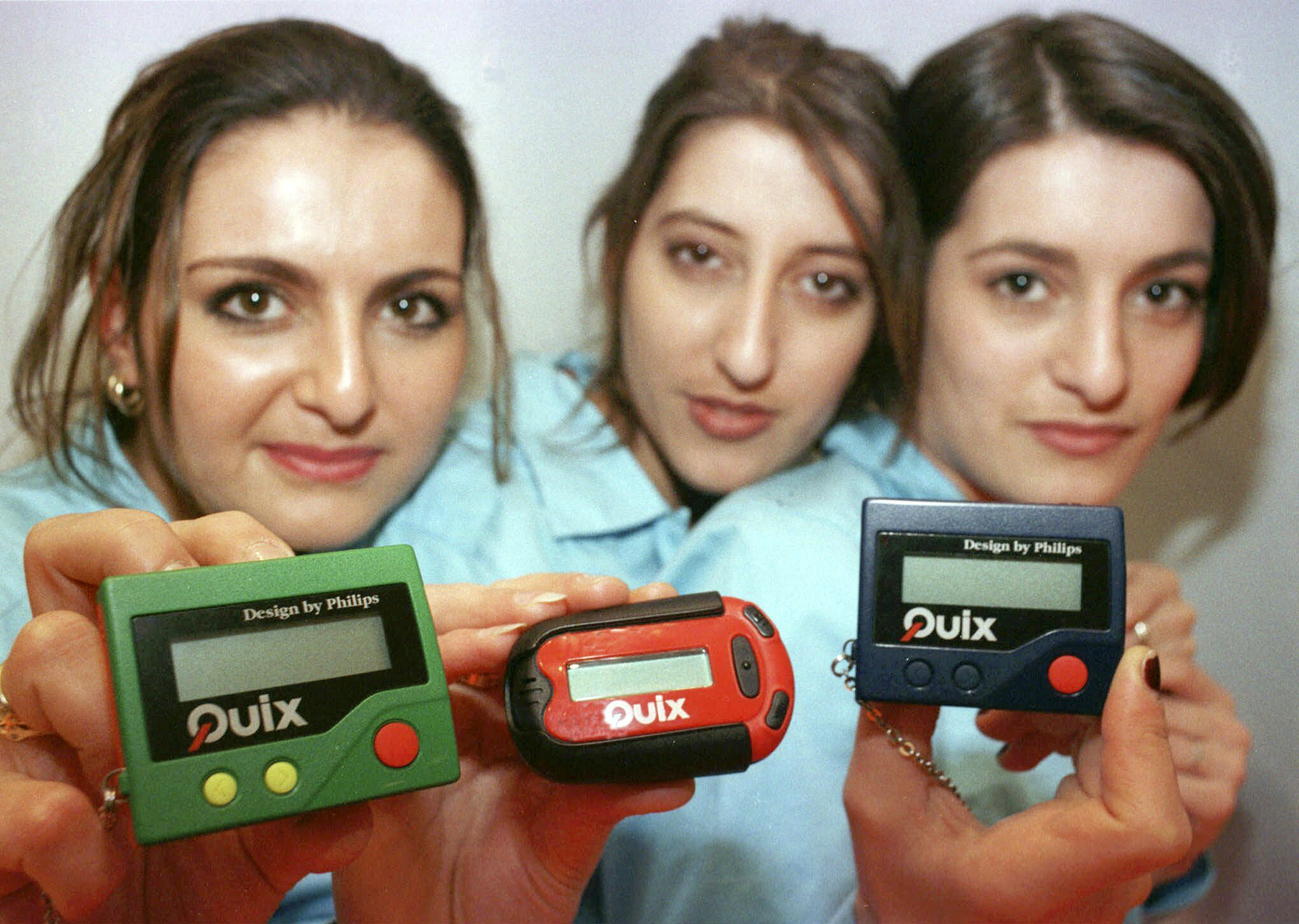 FILE - Three women hold the pager 'Quix' as they present it at CeBIT '97 in Hannover, Germany, Tuesday March 18, 1997. The beep-beep-beep of a small black box on your belt or in your pocket was something of a status symbol decades before the smartphone wiped it from popular culture. (AP Photo/Fabian Bimmer, File)