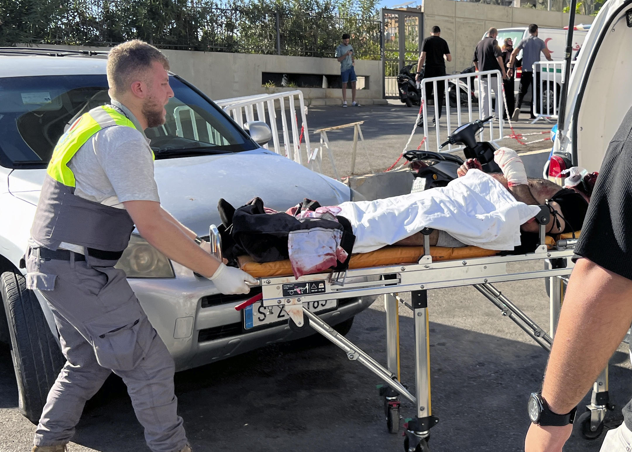 FILE - A Civil Defense first-responder carries a wounded man whose handheld pager exploded at al-Zahraa hospital in Beirut, on Sept. 17, 2024. (AP Photo/Hussein Malla, File)