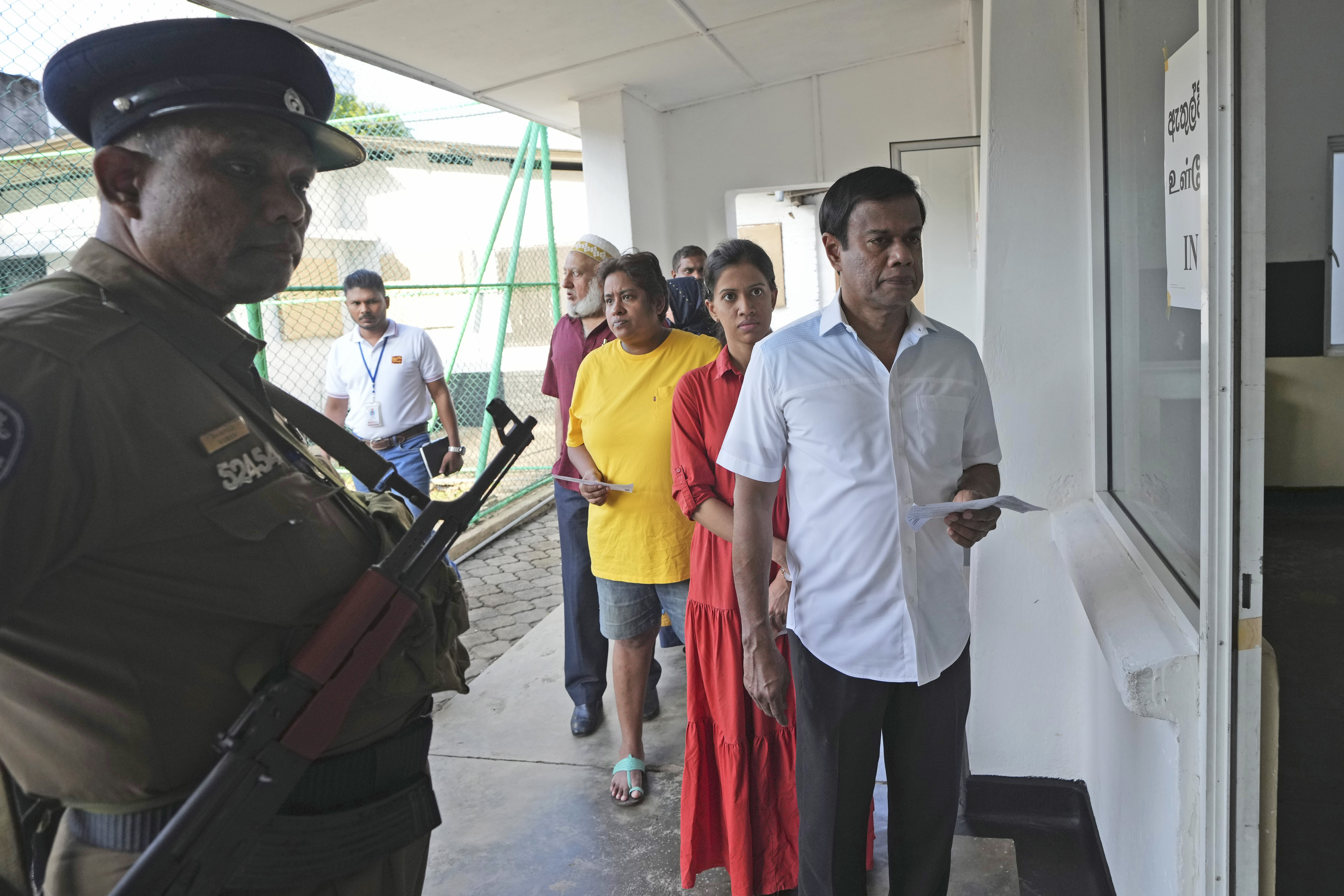 People wait in a queue to casts their votes at a polling station in Colombo, Sri Lanka, Saturday, Sept. 21, 2024. (AP Photo/Rajesh Kumar Singh)