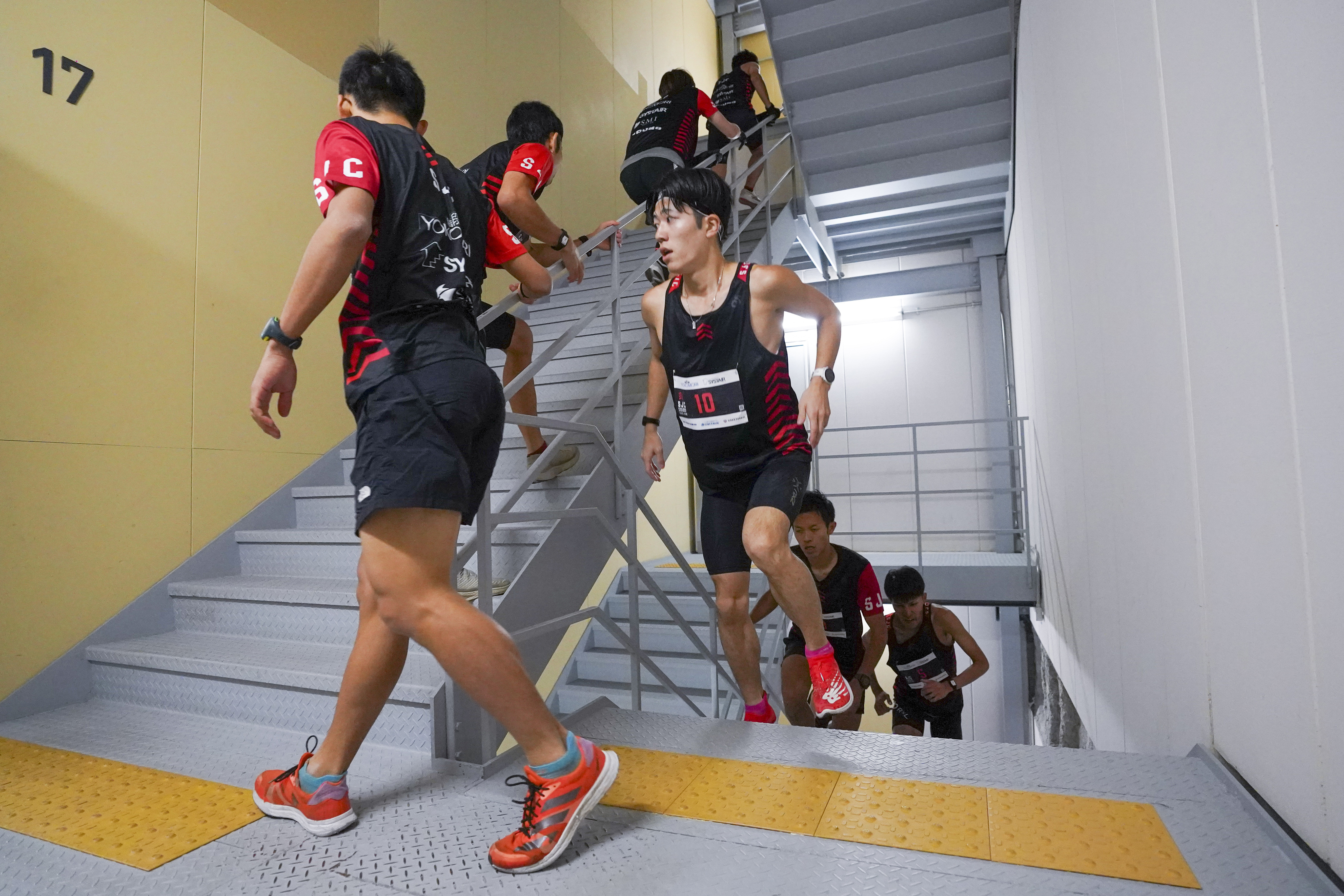 In this photo provided by ISF/Meeting, competitors climb stairs during a race of Stairclimbing World Championships in Osaka, western Japan, on Nov. 19, 2023. (ISF/MEETING via AP)