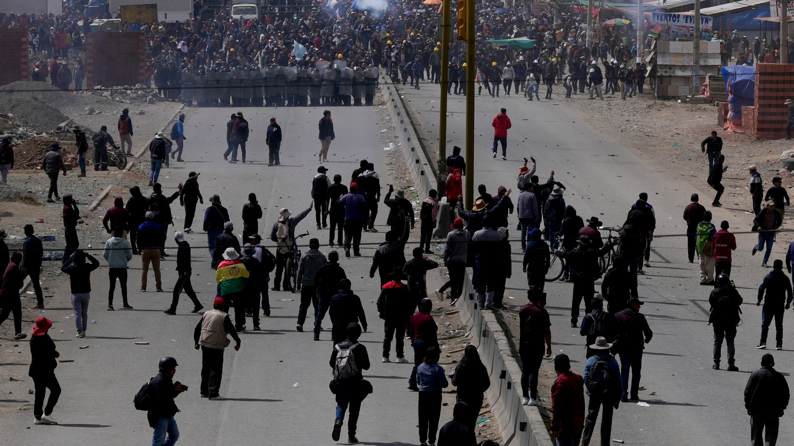 Supporters of former President Evo Morales, below, advance toward supporters of current president Luis Arce in El Alto, Bolivia, Sunday, Sept. 22, 2024. (AP Photo/Juan Karita)