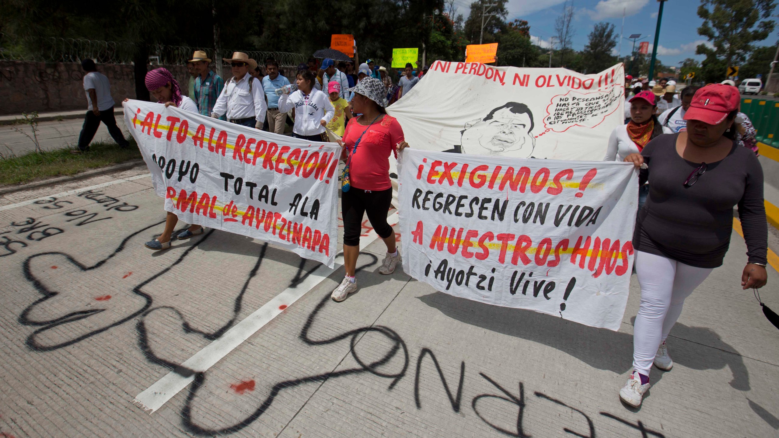 FILE - People protest the disappearance of 43 students from Raúl Isidro Burgos Rural Normal School and demand authorities find them, in Chilpancingo, Guerrero state, Mexico, Oct. 8, 2014. (AP Photo/Eduardo Verdugo, File)