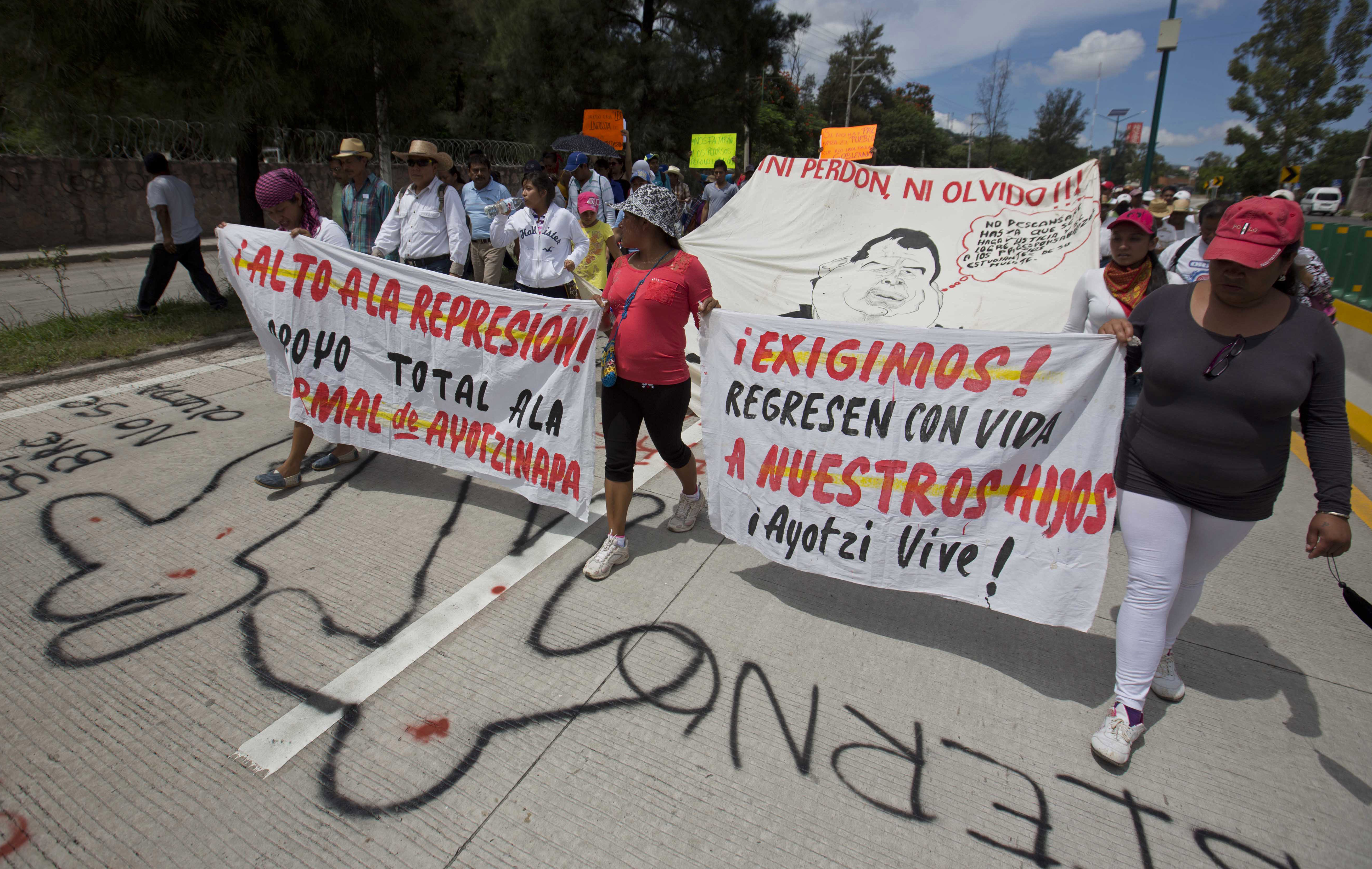 FILE - People protest the disappearance of 43 students from Raúl Isidro Burgos Rural Normal School and demand authorities find them, in Chilpancingo, Guerrero state, Mexico, Oct. 8, 2014. (AP Photo/Eduardo Verdugo, File)