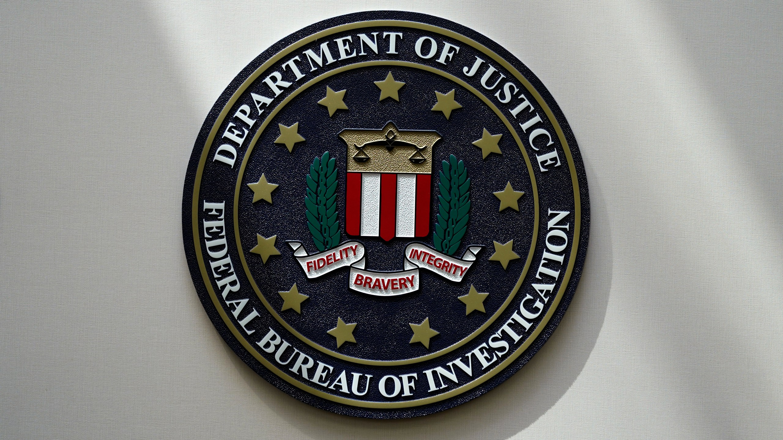 FILE - An FBI seal is seen on a wall on Aug. 10, 2022, in Omaha, Neb. Violent crime in the US dropped again in 2023, according to FBI statistics that show a continued trend downward after a coronavirus pandemic-era crime spike. The report released Monday shows overall violent crime ticked down an estimated 3% in 2023 from the year before, according to the FBI. (AP Photo/Charlie Neibergall, File)