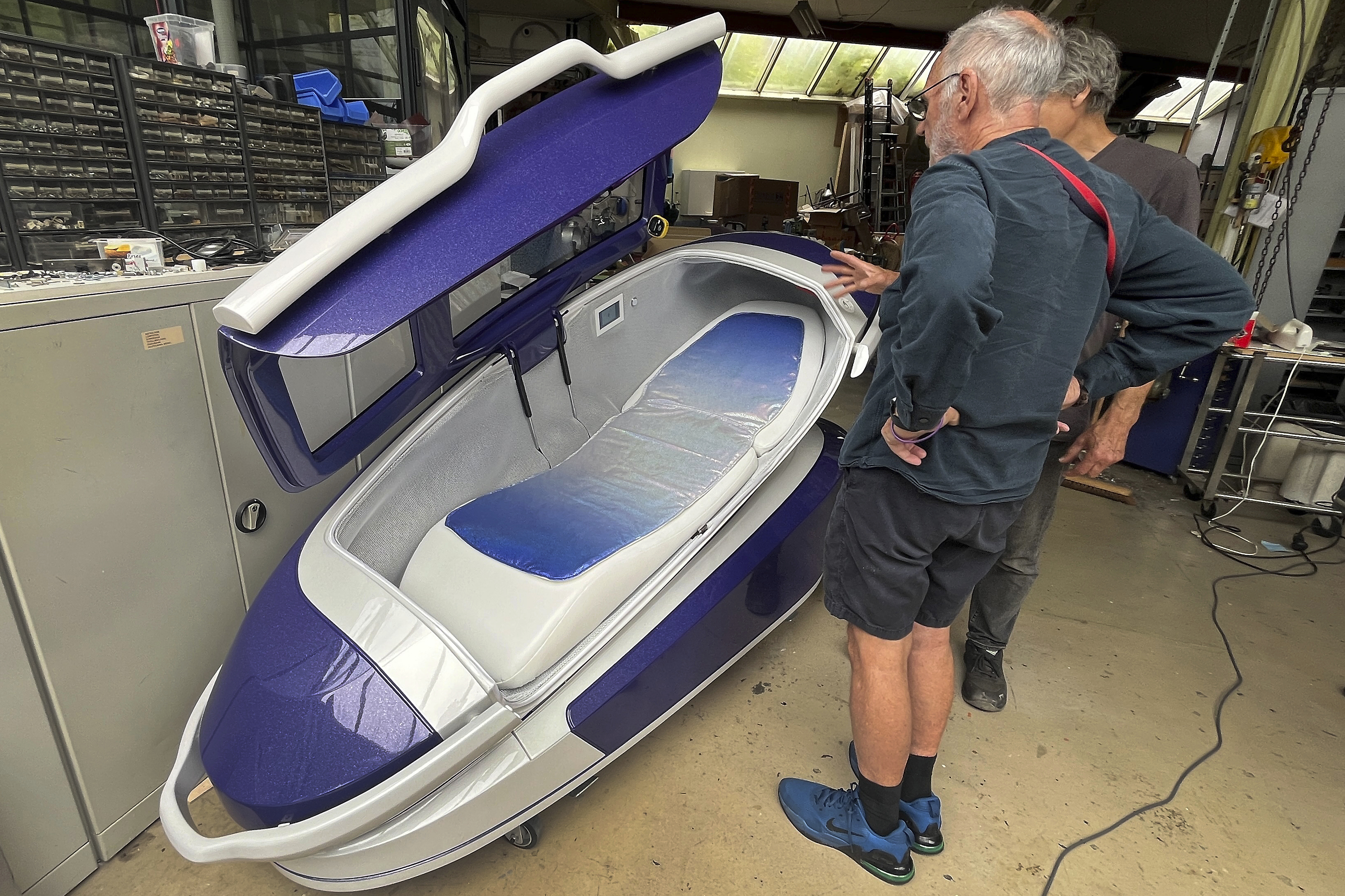 Philip Nitschke, front, stands next to a 'suicide pod' known as 'The Sarco' in Rotterdam, The Netherlands, July 8, 2024. (AP Photo/Ahmad Seir)