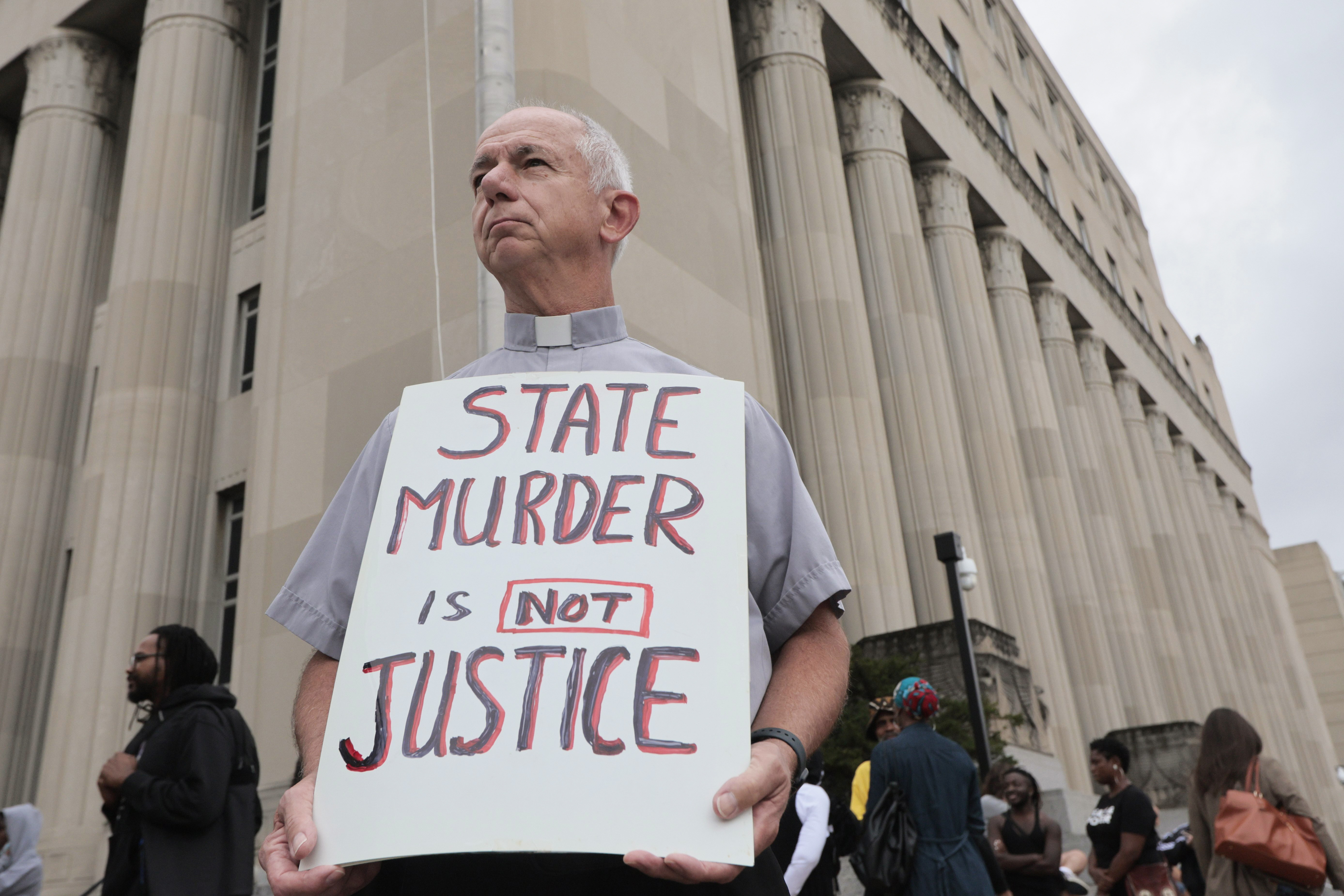 Deacon Dave Billips, with the Office of Peace and Justice with the St. Louis Archdiocese, holds a sign as he stands with protesters holding space to halt the execution of Marcellus Williams on Tuesday, Sept. 24, 2024, outside the Carnahan Courthouse in St. Louis. (Laurie Skrivan/St. Louis Post-Dispatch via AP)