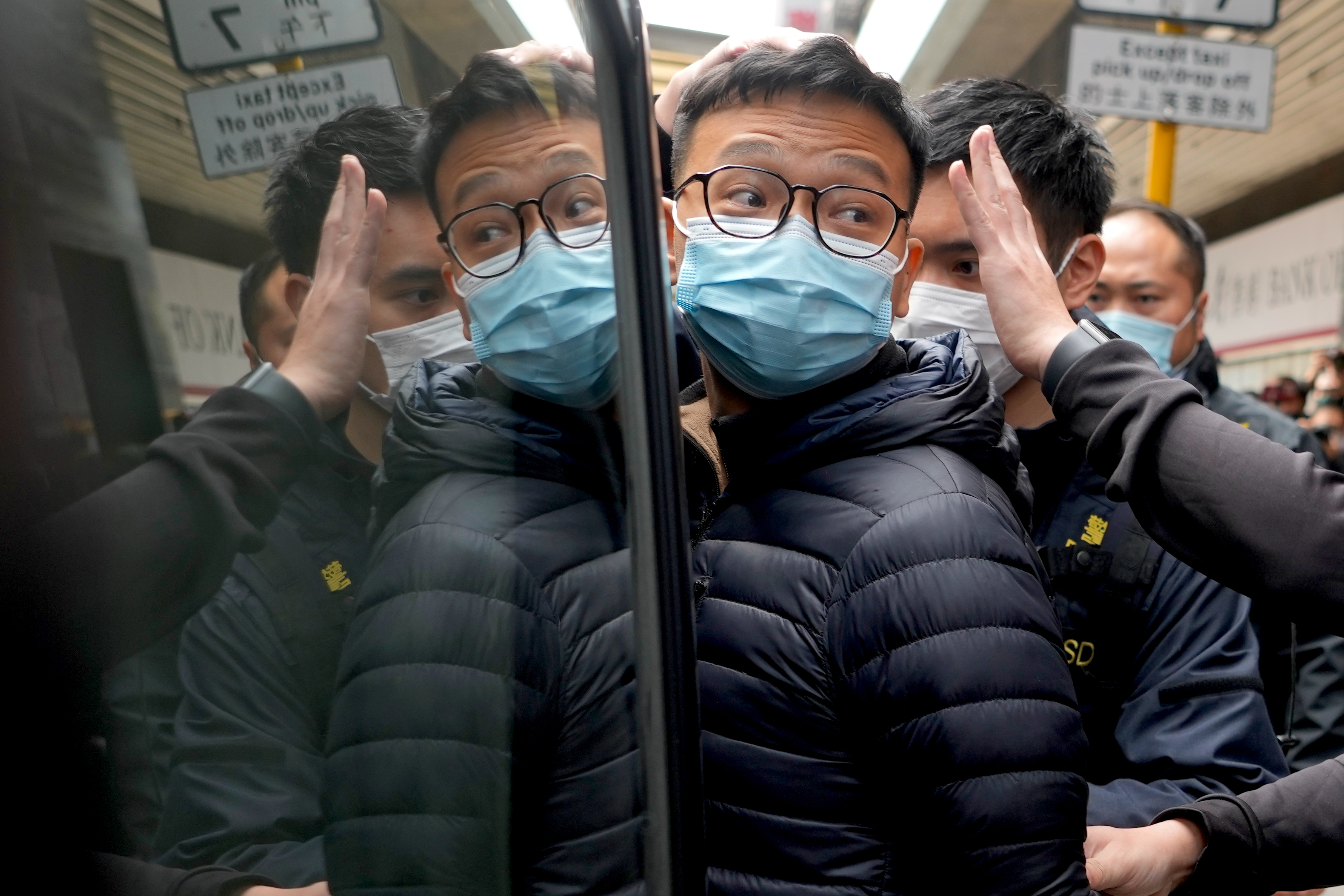 FILE - Then Editor of Stand News Patrick Lam, center, is escorted by police officers into a van after they searched evidence at his office in Hong Kong, Dec. 29, 2021. (AP Photo/Vincent Yu, File)