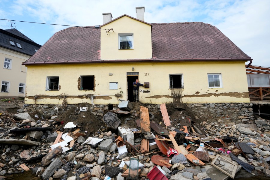 FILE - A man throws damaged goods and furniture off a house as residents return to clean up after recent floods in Mikulovice, Czech Republic, Sept. 19, 2024. (AP Photo/Petr David Josek, File)