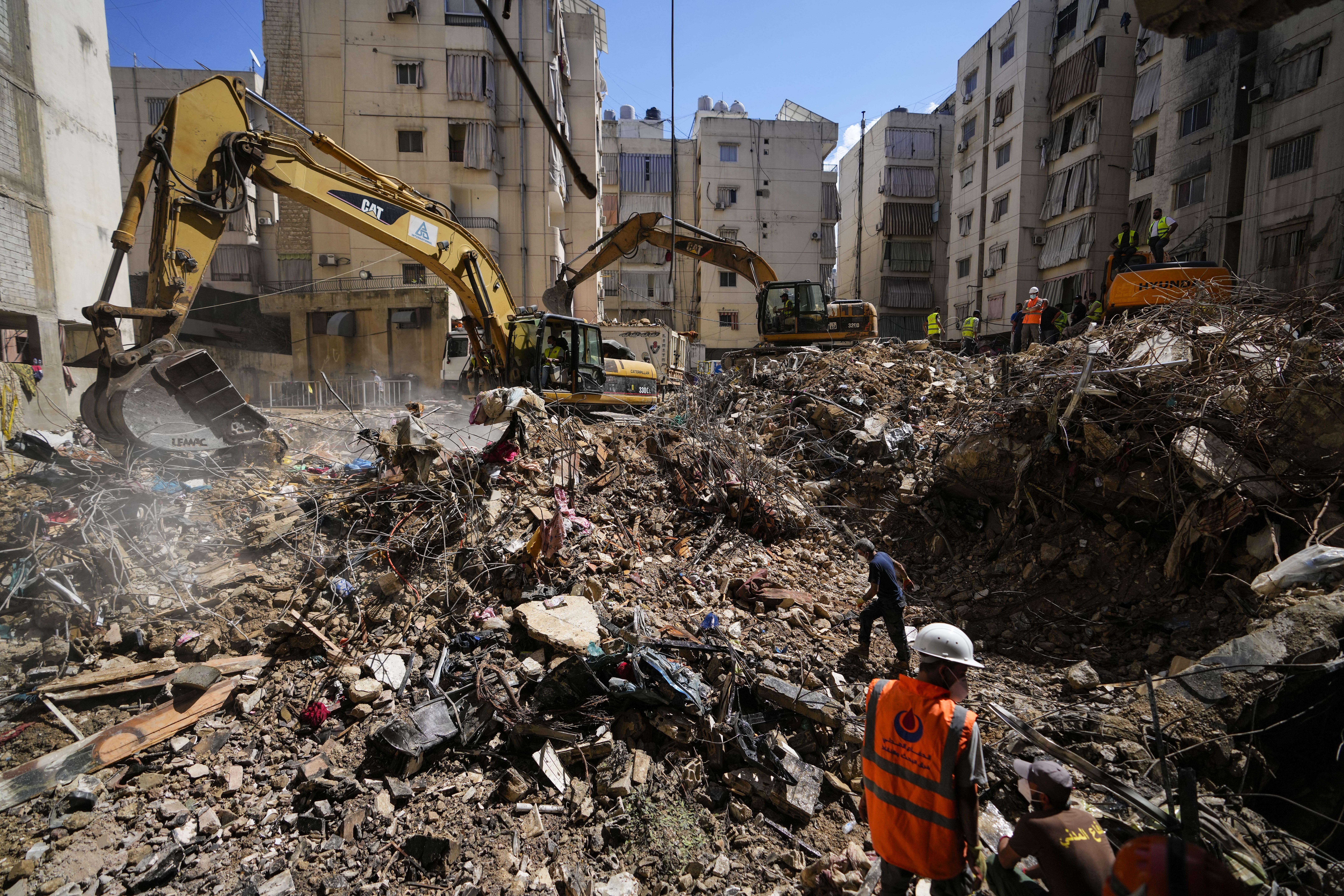 Emergency workers use excavators to clear the rubble at the site of Friday's Israeli strike in Beirut's southern suburbs, Lebanon, Monday, Sept. 23, 2024. (AP Photo/Hassan Ammar)