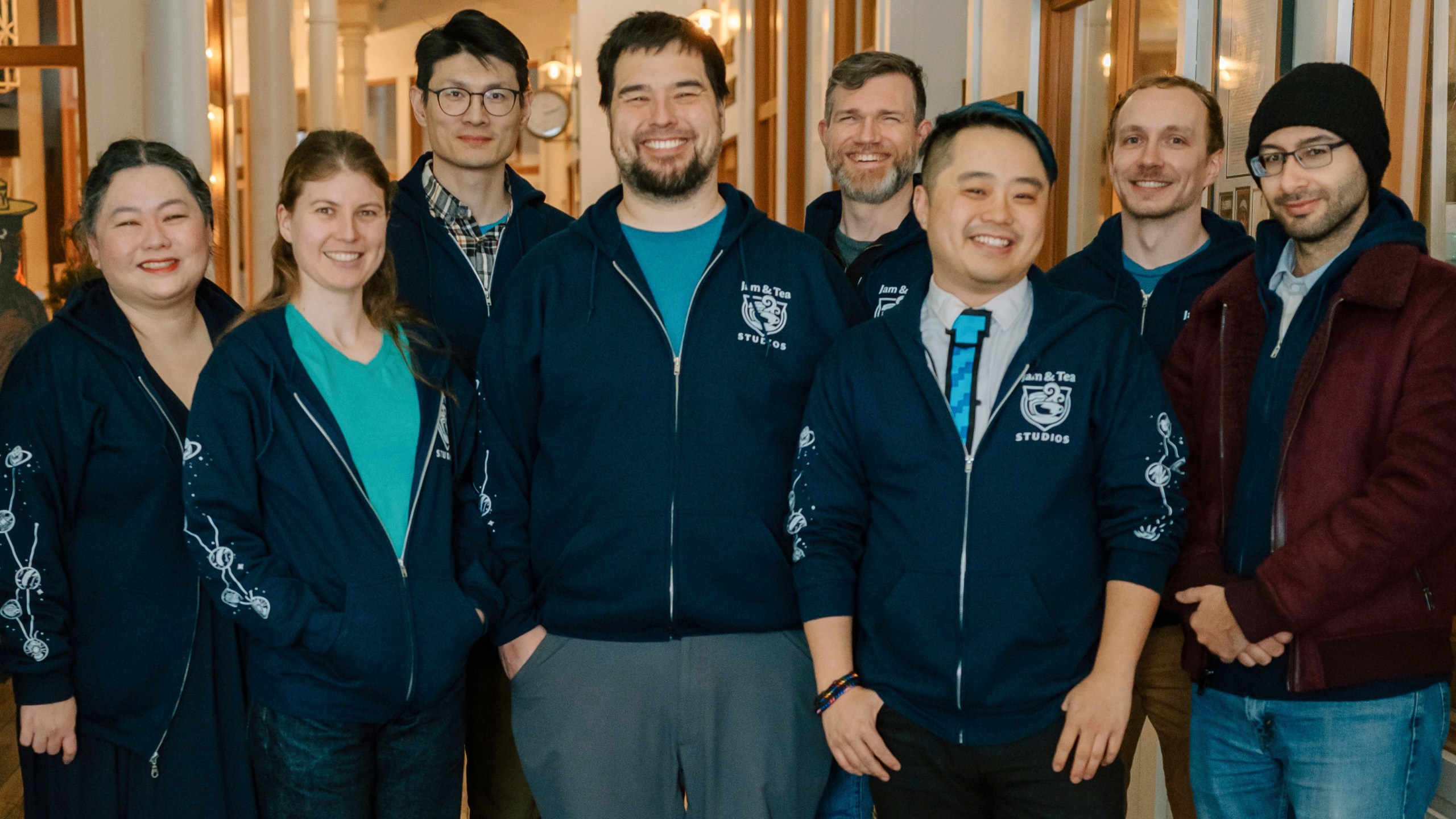 Jam & Tea Studios founders, left to right, Michael Yichao, center, Carl Kwoh, third from right, and J. Aaron Farr, fourth from right, pose with staff on Jan. 18, 2024, in Roslyn, Wash. (Lutisha Aubrey Photography via AP)