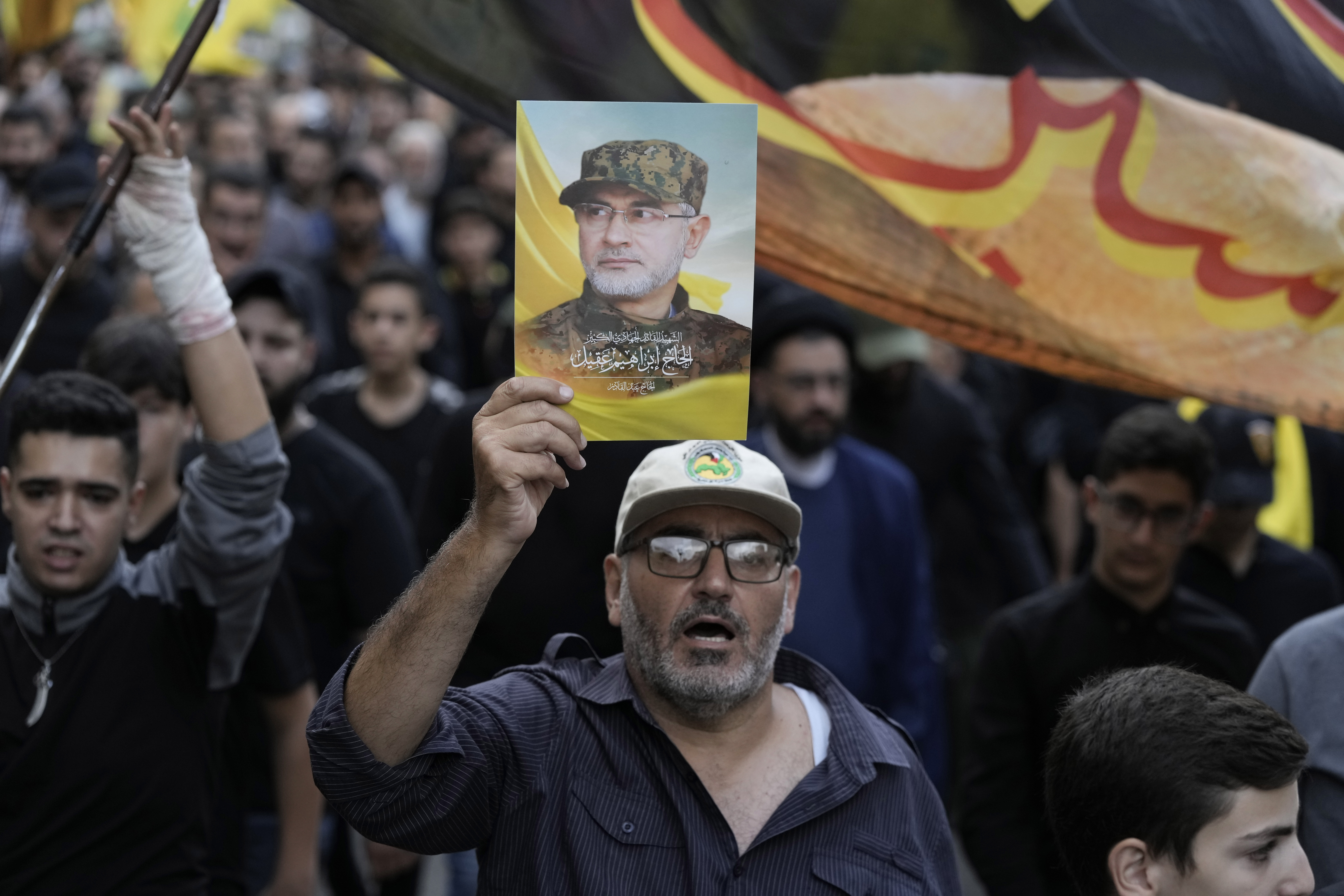 Hezbollah supporters carry pictures of Hezbollah commander Ibrahim Akil during his funeral procession in Beirut's southern suburb, Sunday, Sept. 22, 2024. (AP Photo/Bilal Hussein)