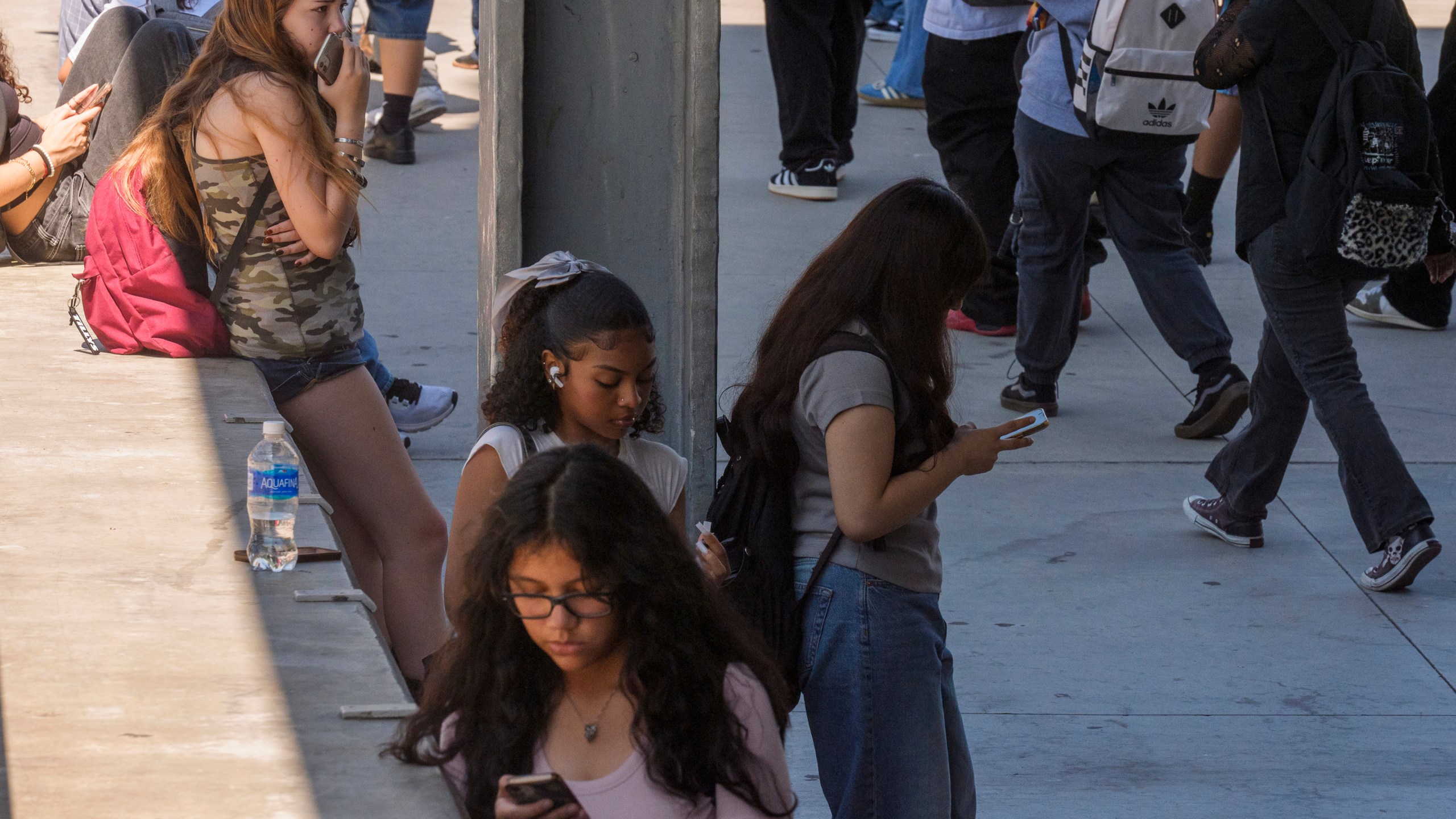 FILE - Students use their cellphones as they leave for the day the Ramon C. Cortines School of Visual and Performing Arts High School in downtown Los Angeles, Aug. 13, 2024. (AP Photo/Damian Dovarganes, File)