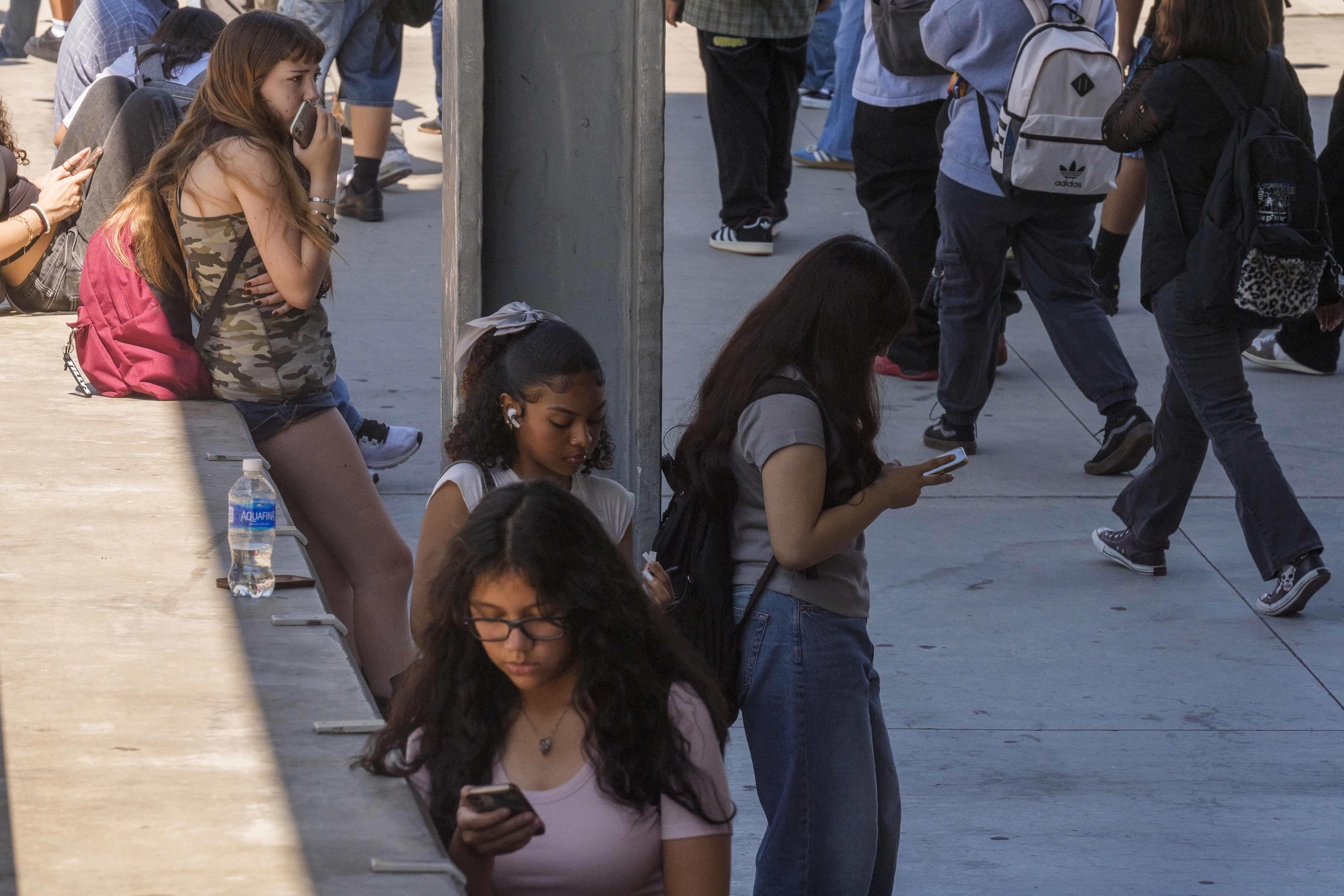 FILE - Students use their cellphones as they leave for the day the Ramon C. Cortines School of Visual and Performing Arts High School in downtown Los Angeles, Aug. 13, 2024. (AP Photo/Damian Dovarganes, File)