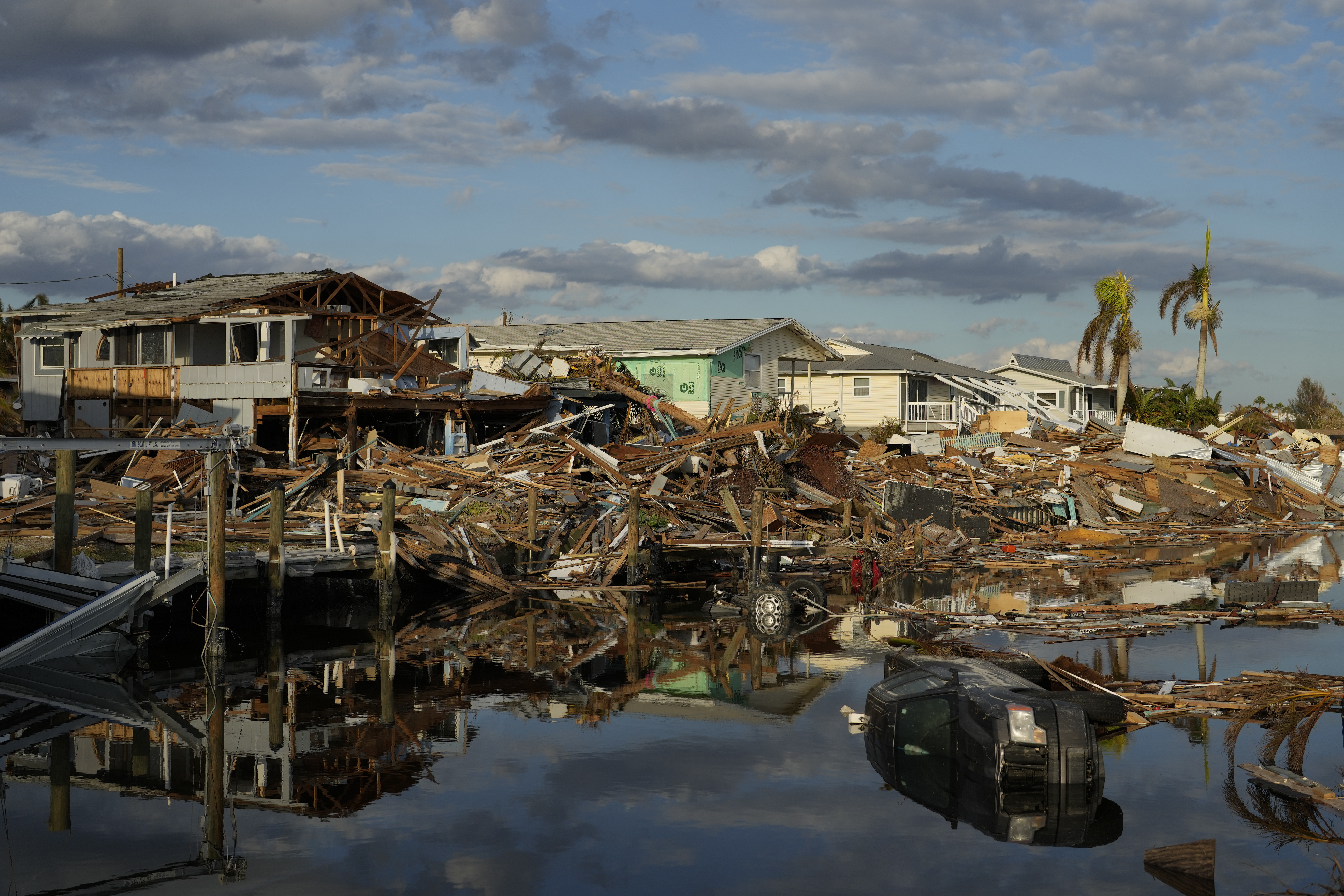 FILE - Cars and debris from washed away homes line a canal in Fort Myers Beach, Fla., Oct. 5, 2022, one week after the passage of Hurricane Ian. (AP Photo/Rebecca Blackwell, File)