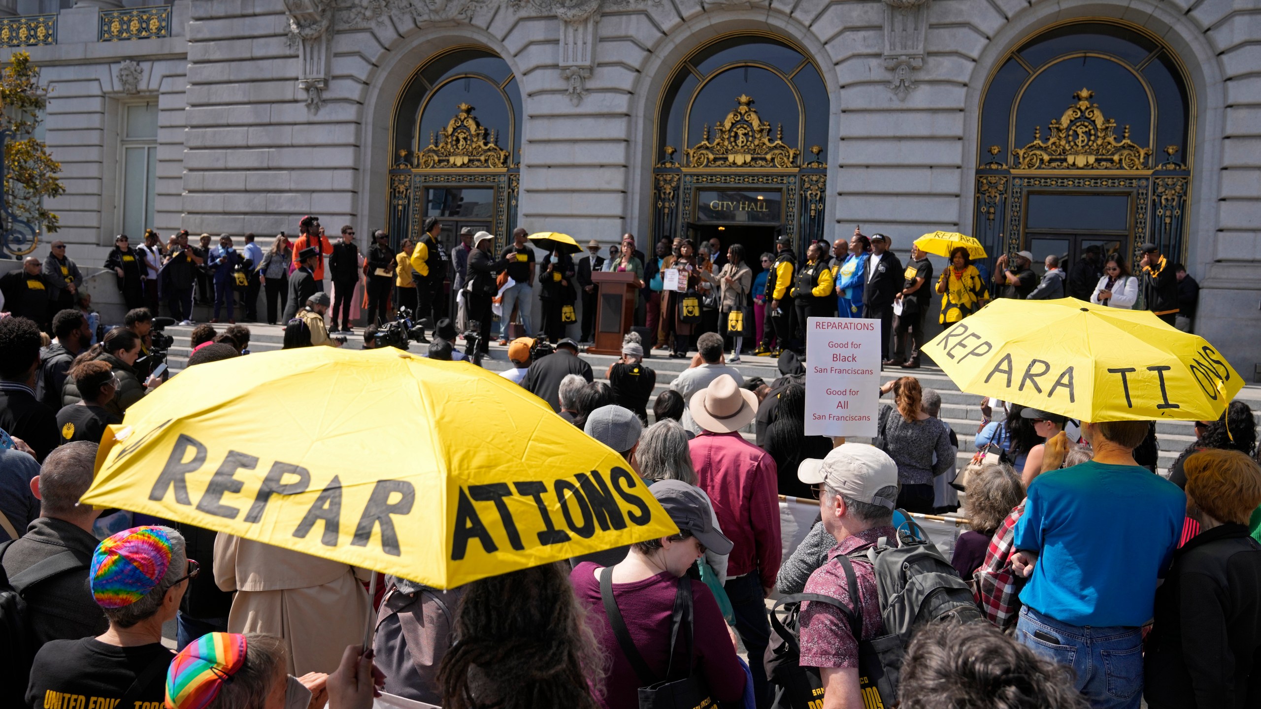 FILE - People listen during a rally in support of reparations for African Americans outside City Hall in San Francisco, Tuesday, Sept. 19, 2023. (AP Photo/Eric Risberg, File)