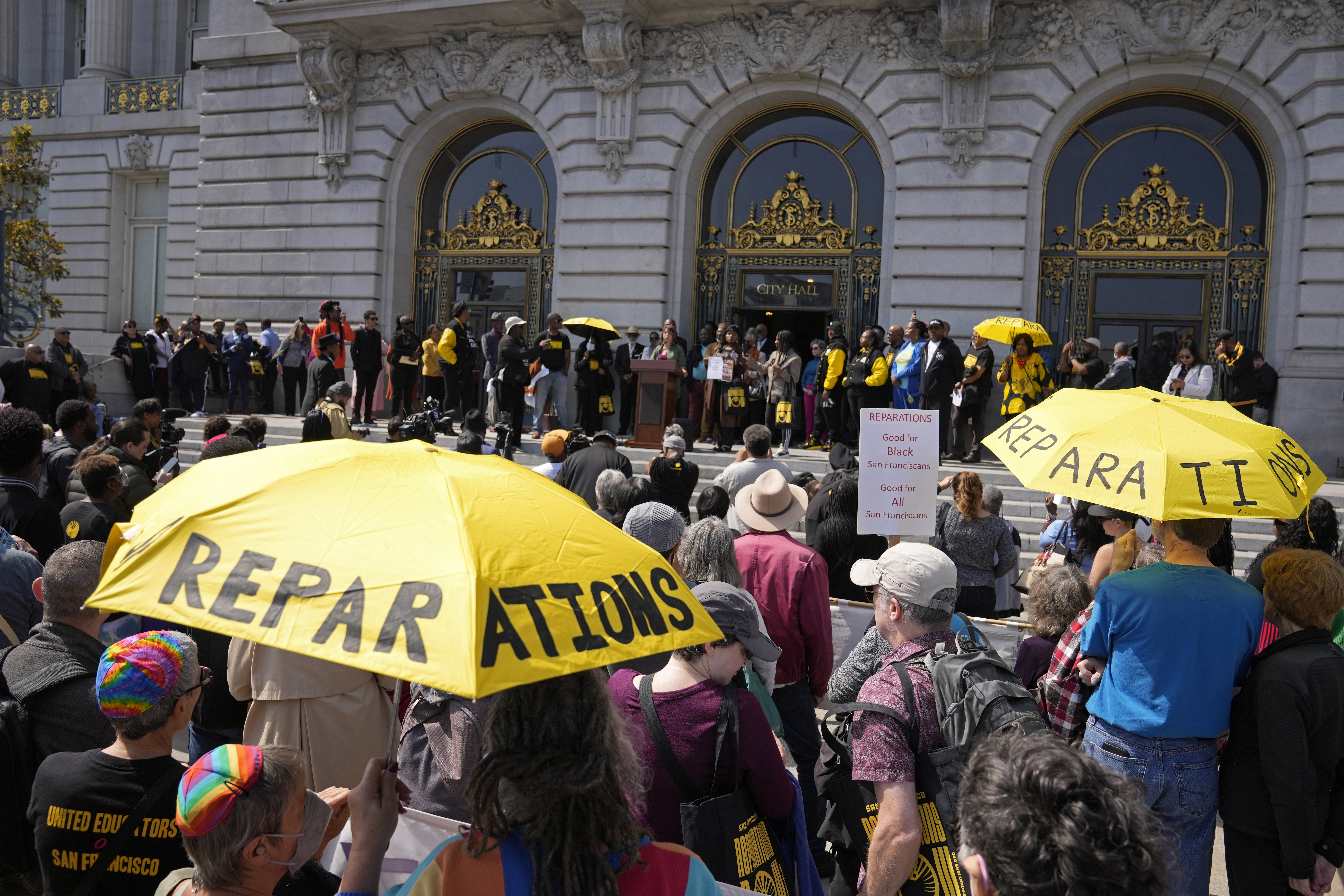 FILE - People listen during a rally in support of reparations for African Americans outside City Hall in San Francisco, Tuesday, Sept. 19, 2023. (AP Photo/Eric Risberg, File)