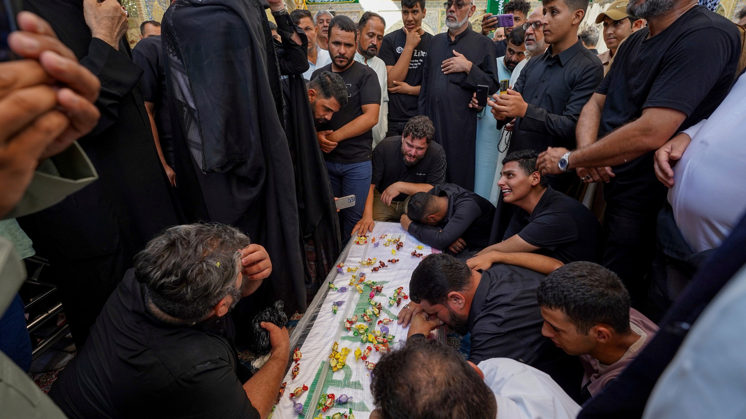 Relatives mourn over the coffin of Zulfikar Dergham Musa Al-Jabouri, in Najaf, Iraq, Thursday, Sept. 26, 2024 who died in Israeli airstrikes on Sept. 23 fighting alongside Hezbollah in Tyre, south Lebanon. (AP Photo/Anmar Khalil)