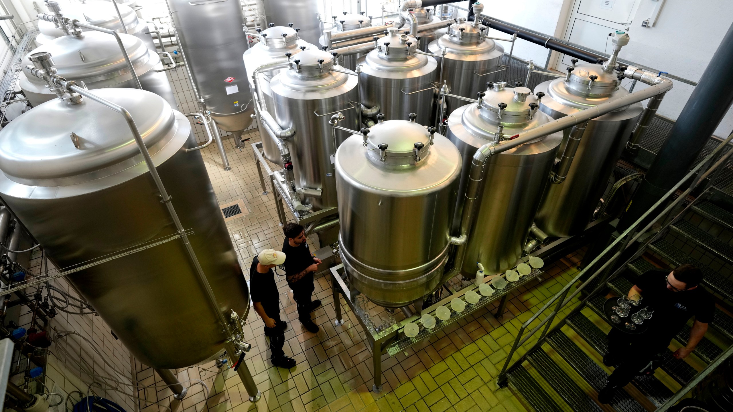 Employees of the Technical University of Munich work at the brewery plant in Freising, Germany, Thursday, Sept. 19, 2024. (AP Photo/Matthias Schrader)