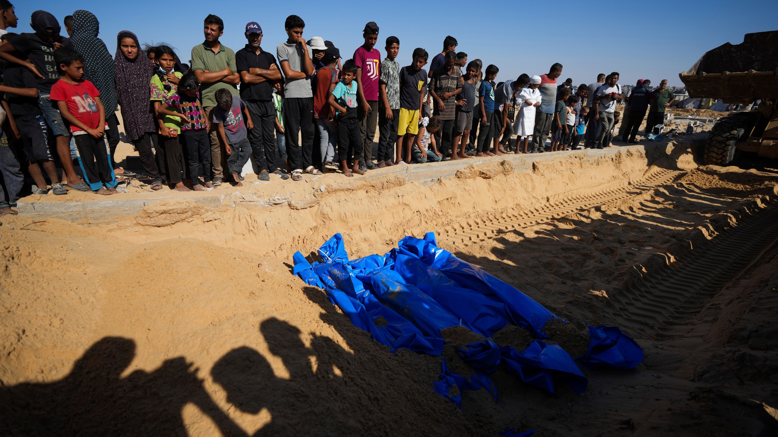 People bury the bodies of Palestinians taken by the Israeli military during operations in Gaza and returned this week, in Khan Younis, Gaza Strip, Thursday, Sept. 26, 2024. (AP Photo/Abdel Kareem Hana)