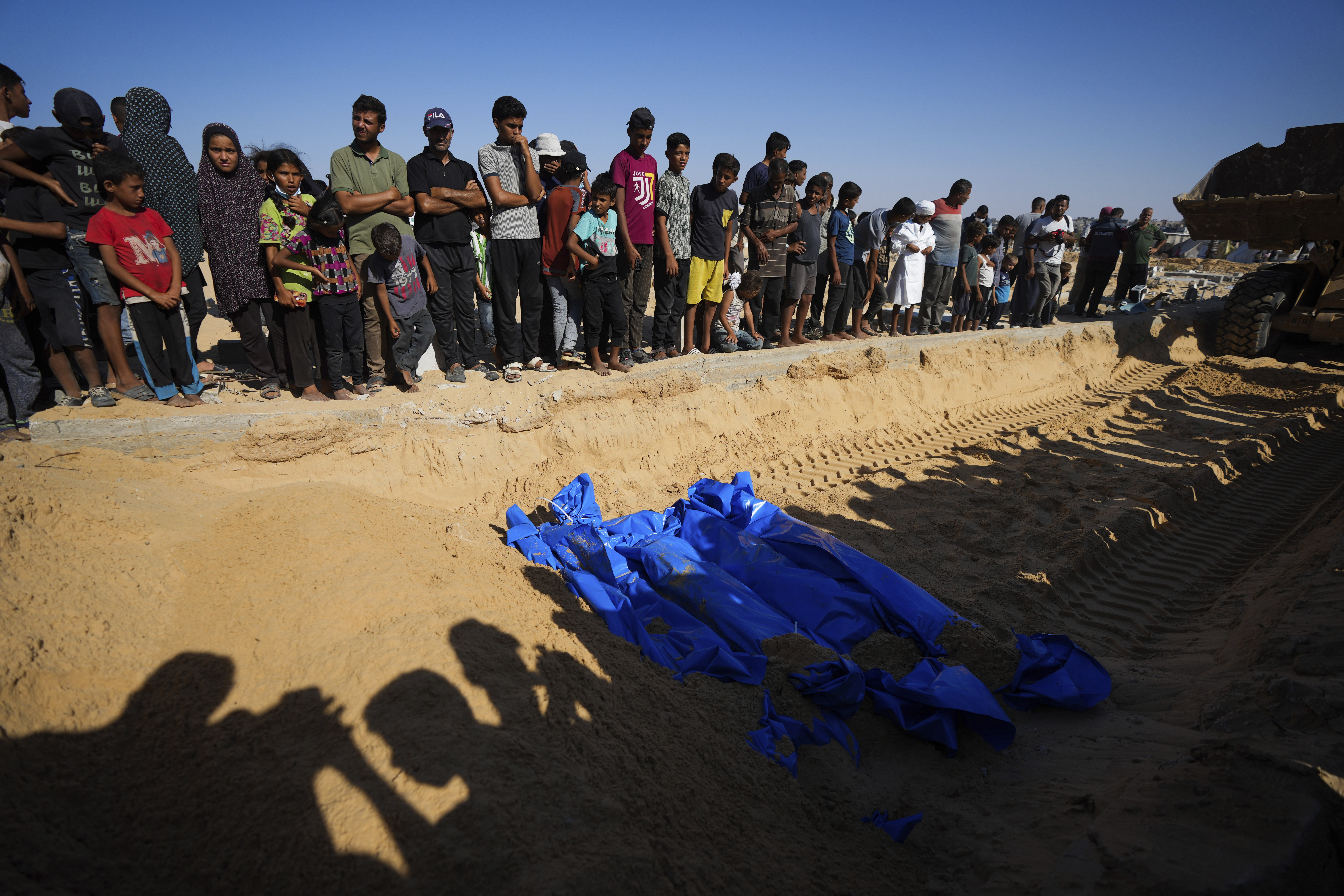 People bury the bodies of Palestinians taken by the Israeli military during operations in Gaza and returned this week, in Khan Younis, Gaza Strip, Thursday, Sept. 26, 2024. (AP Photo/Abdel Kareem Hana)