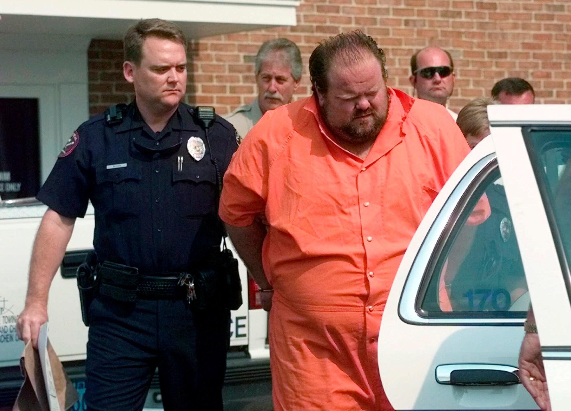 FILE - Officials escort murder suspect Alan Eugene Miller away from the Pelham City Jail in Alabama, Aug. 5, 1999. (AP Photo/Dave Martin, File)