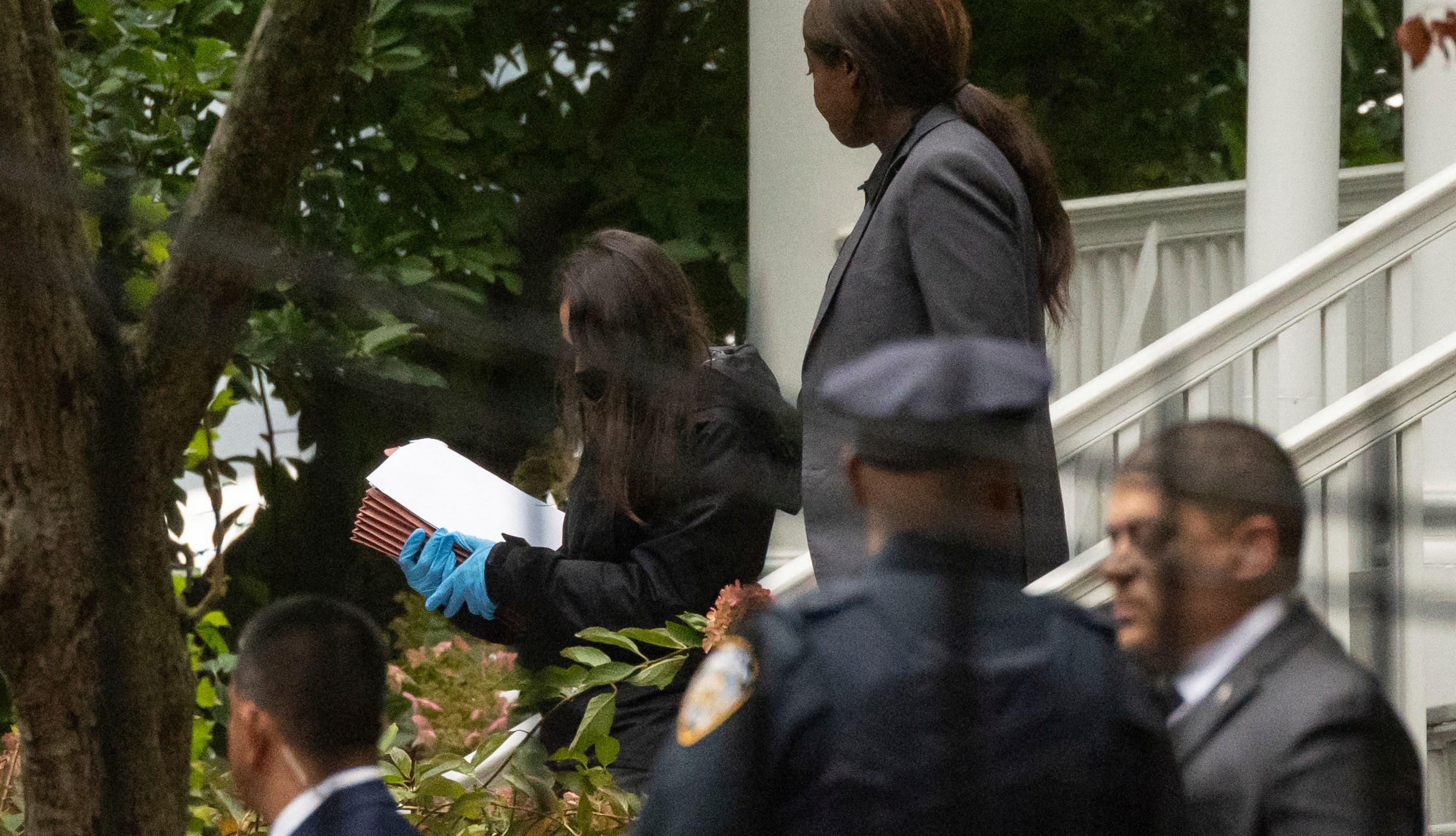 A person wearing gloves and carrying Manila folders exits Gracie Mansion, the official residence of New York City Mayor Eric Adams, Thursday, Sept. 26, 2024, in New York. (AP Photo/Yuki Iwamura)