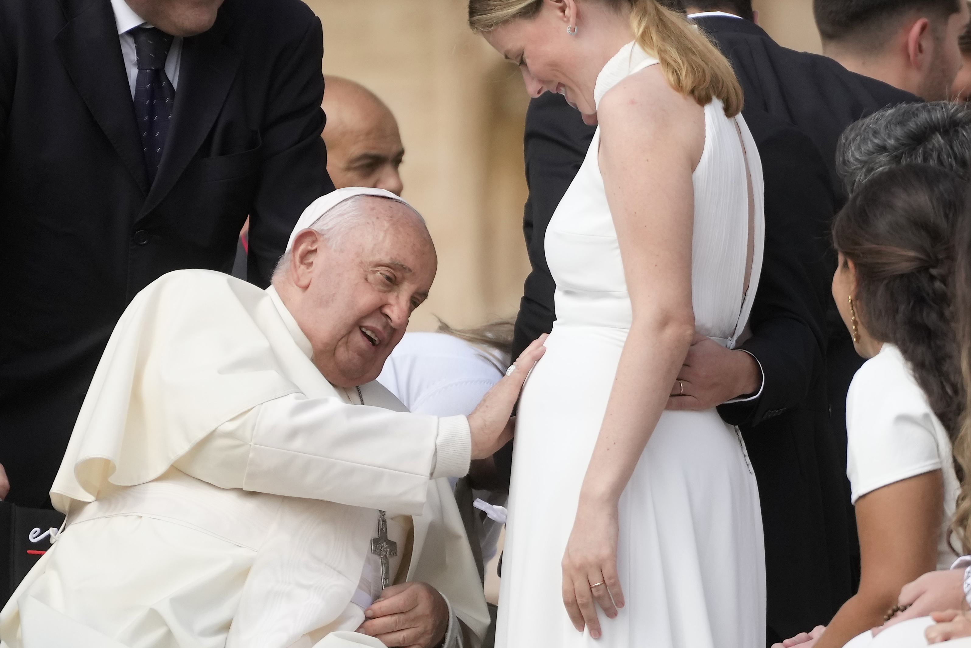 Pope Francis touches the belly of a newly married woman during his weekly general audience in St. Peter's Square, at the Vatican, Wednesday, Sept. 25, 2024. (AP Photo/Gregorio Borgia)