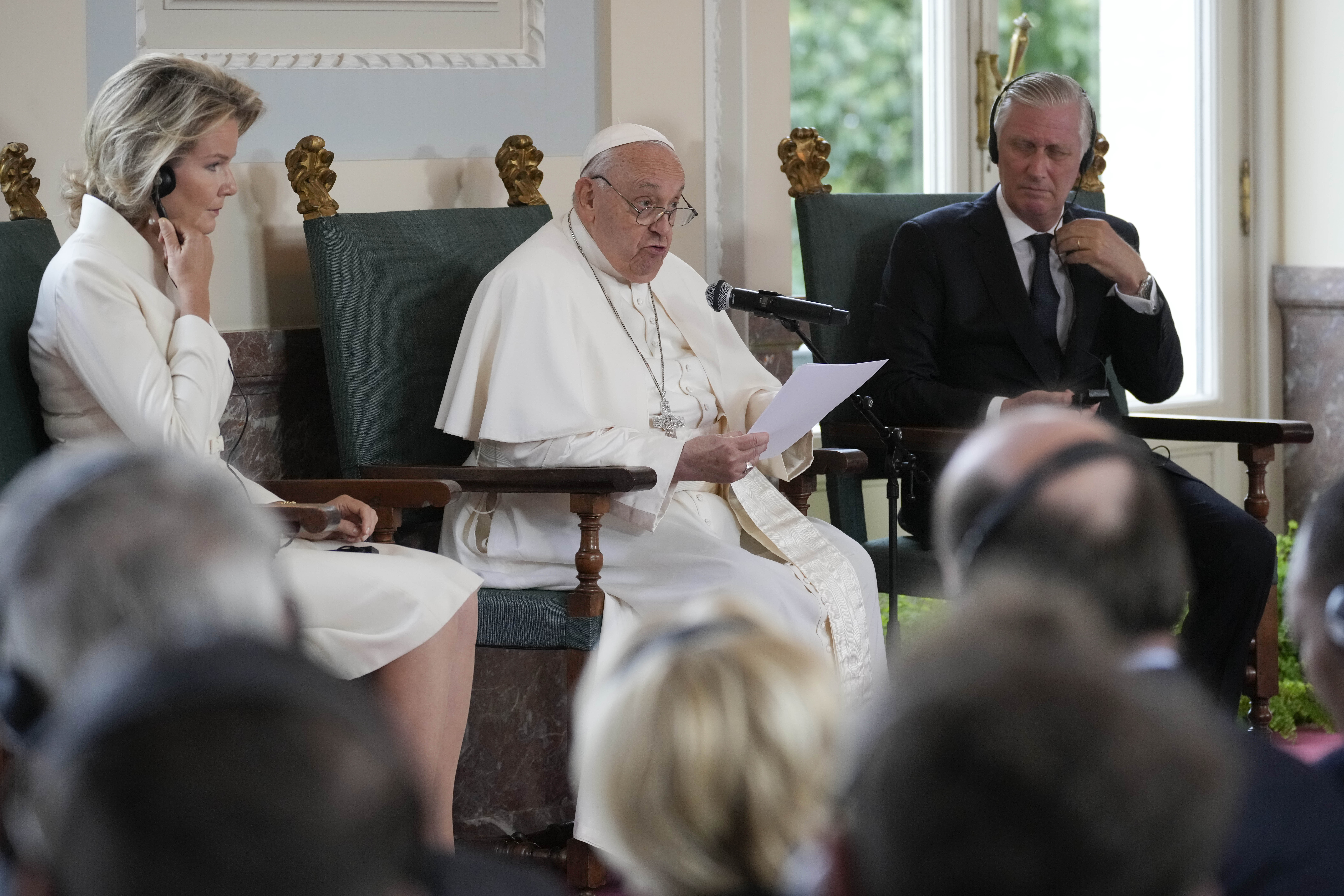 Pope Francis flanked by King Philippe and Queen Mathilde delivers his message during a meeting with the authorities and the civil society in the Grande Galerie of the Castle of Laeken, Brussels, Friday, Sept. 27, 2024. (AP Photo/Andrew Medichini)