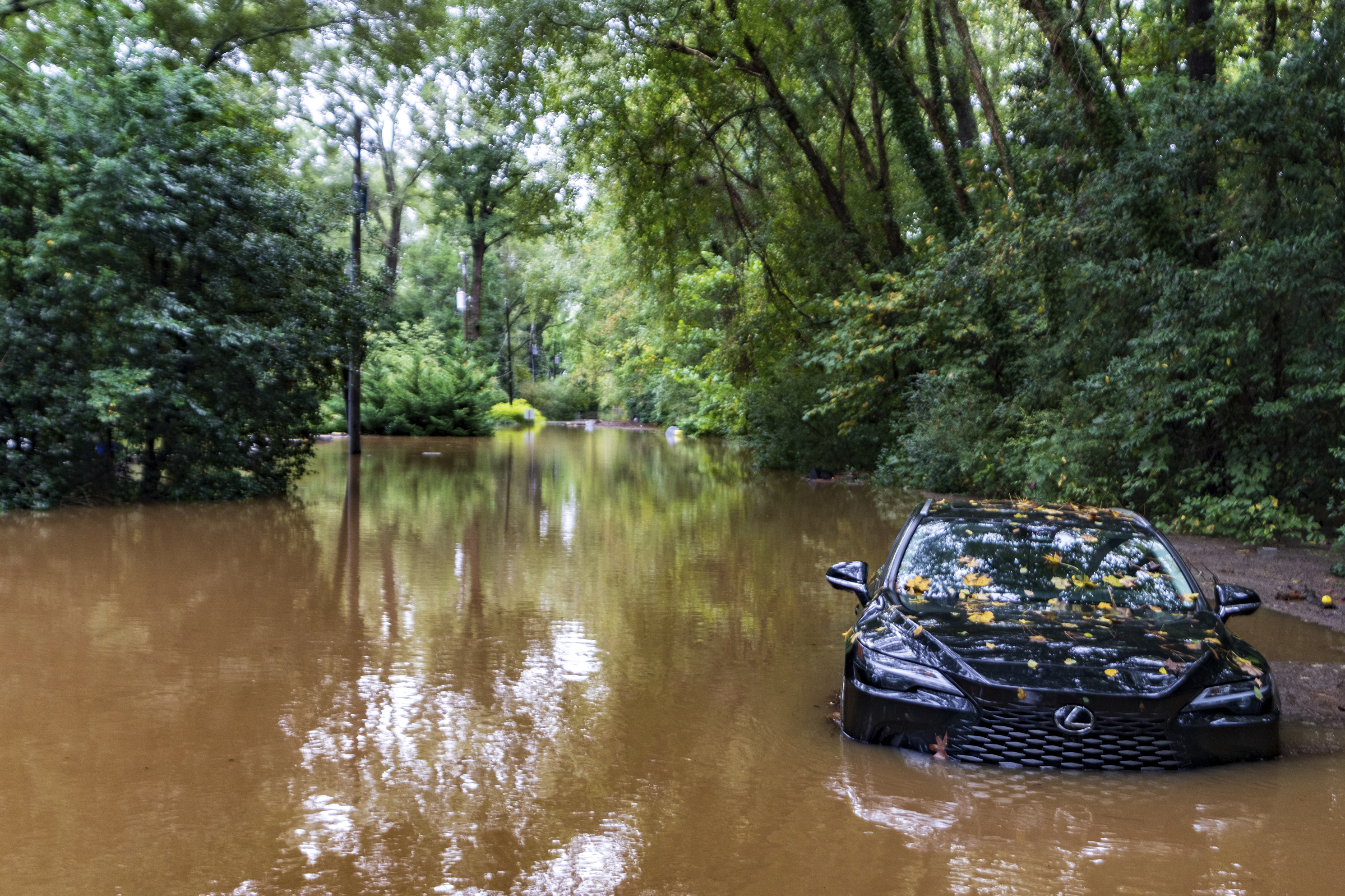 A partially submerged vehicle sits in flood water from after Hurricane Helene passed the area, Friday, Sept 27, 2024, in Atlanta. (AP Photo/Jason Allen)