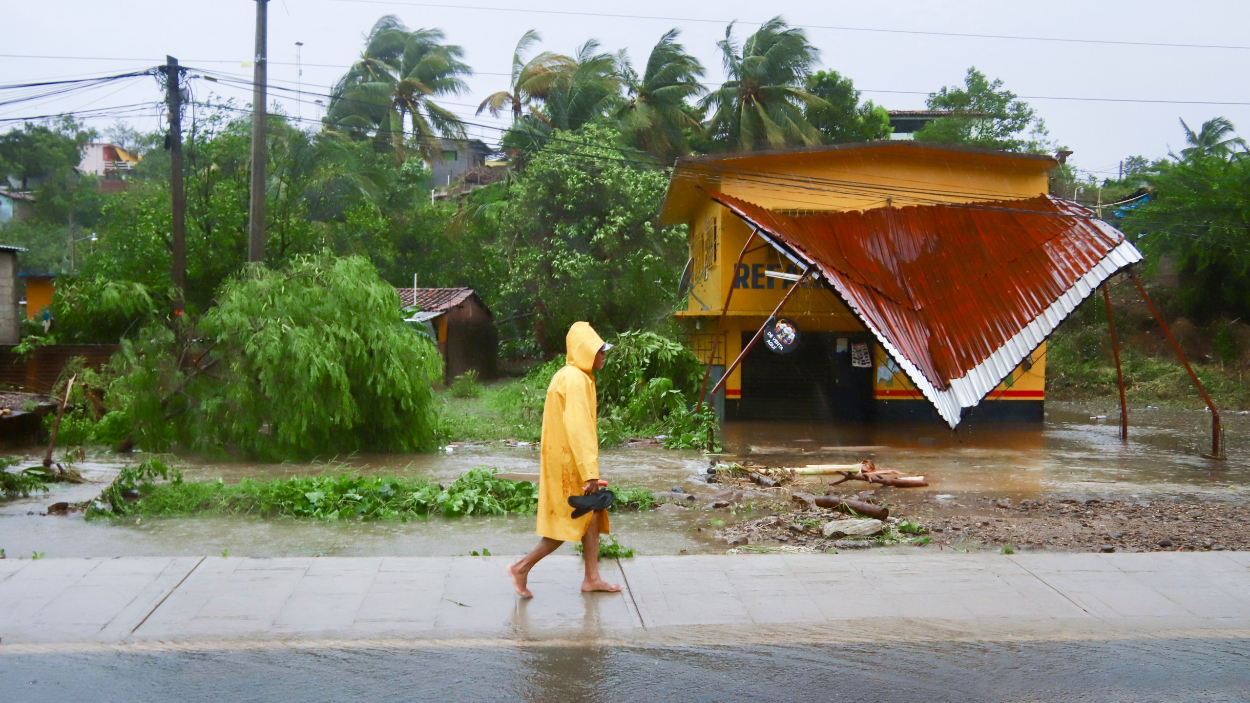 A person walks in the rain after the passing of Hurricane John in Marquelia, Mexico, Tuesday, Sept. 24, 2024. (AP Photo/Luis Alberto Cruz)