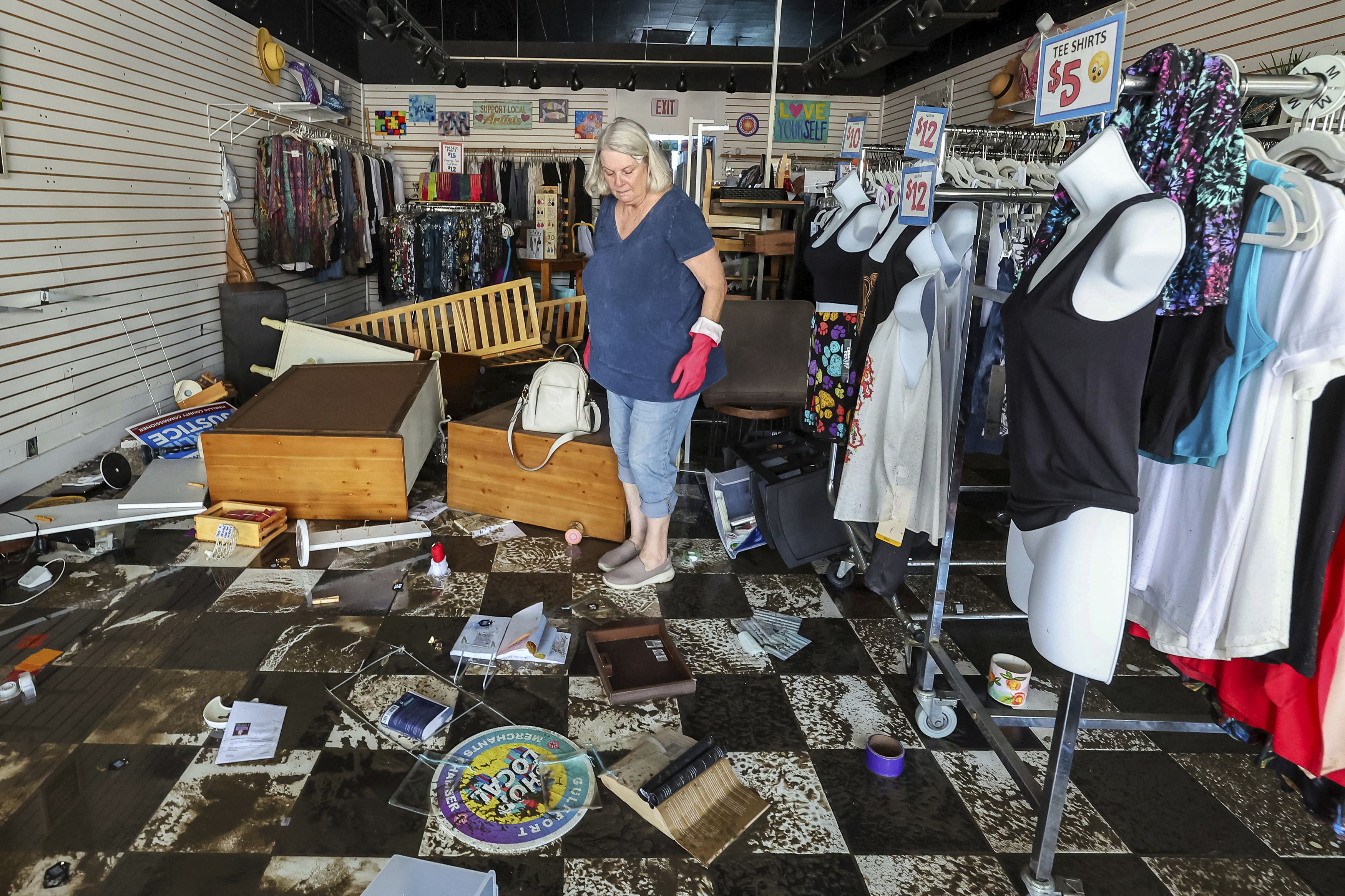 Jill Rice looks over the damage to her store caused by flooding from Hurricane Helene on Friday, Sept. 27, 2024, in Gulfport, Fla. (AP Photo/Mike Carlson)