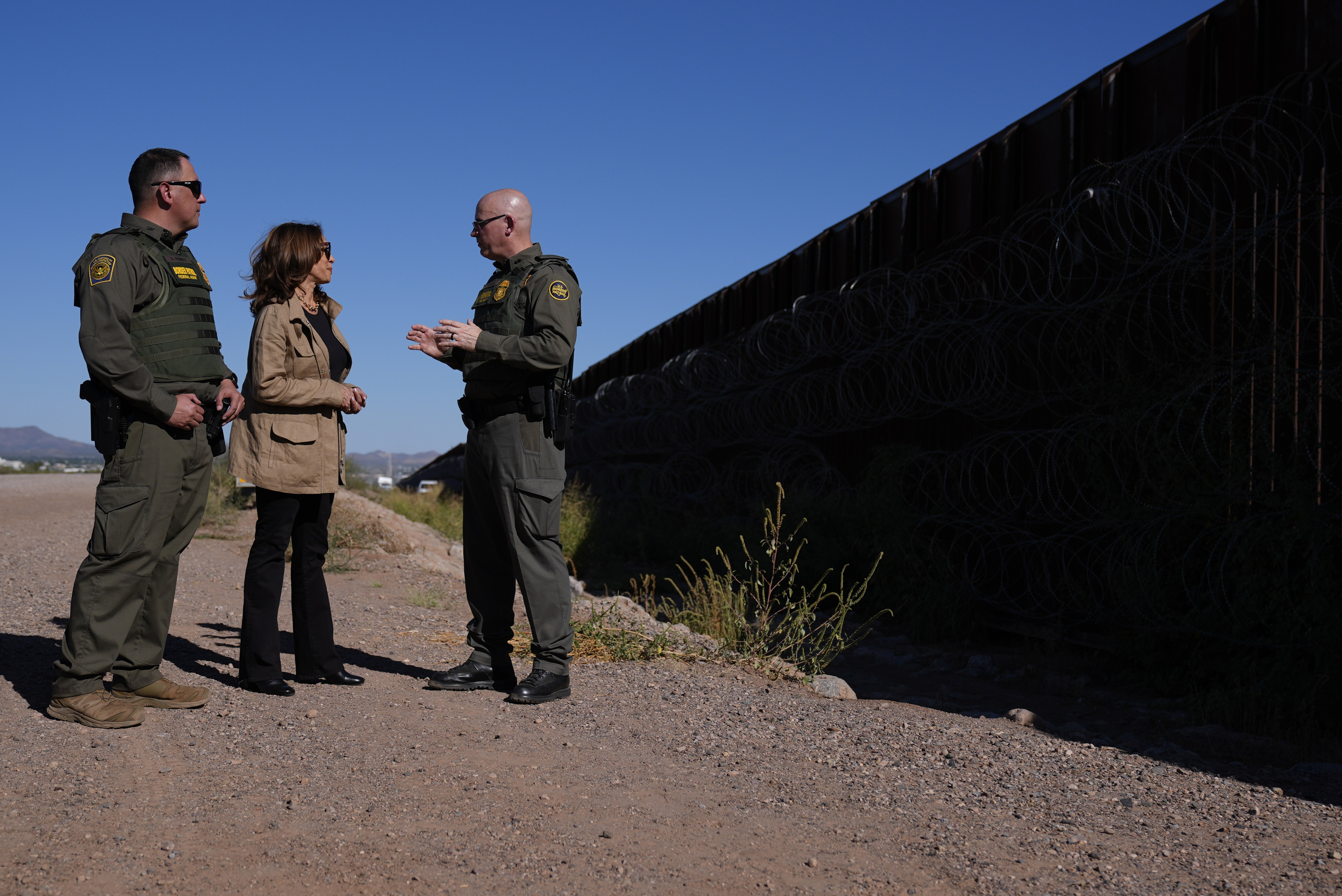 Democratic presidential nominee Vice President Kamala Harris talks with John Modlin, the chief patrol agent for the Tucson Sector of the U.S. Border Patrol, right, and Blaine Bennett, the U.S. Border Patrol Douglas Station border patrol agent in charge, as she visits the U.S. border with Mexico in Douglas, Ariz., Friday, Sept. 27, 2024. (AP Photo/Carolyn Kaster)