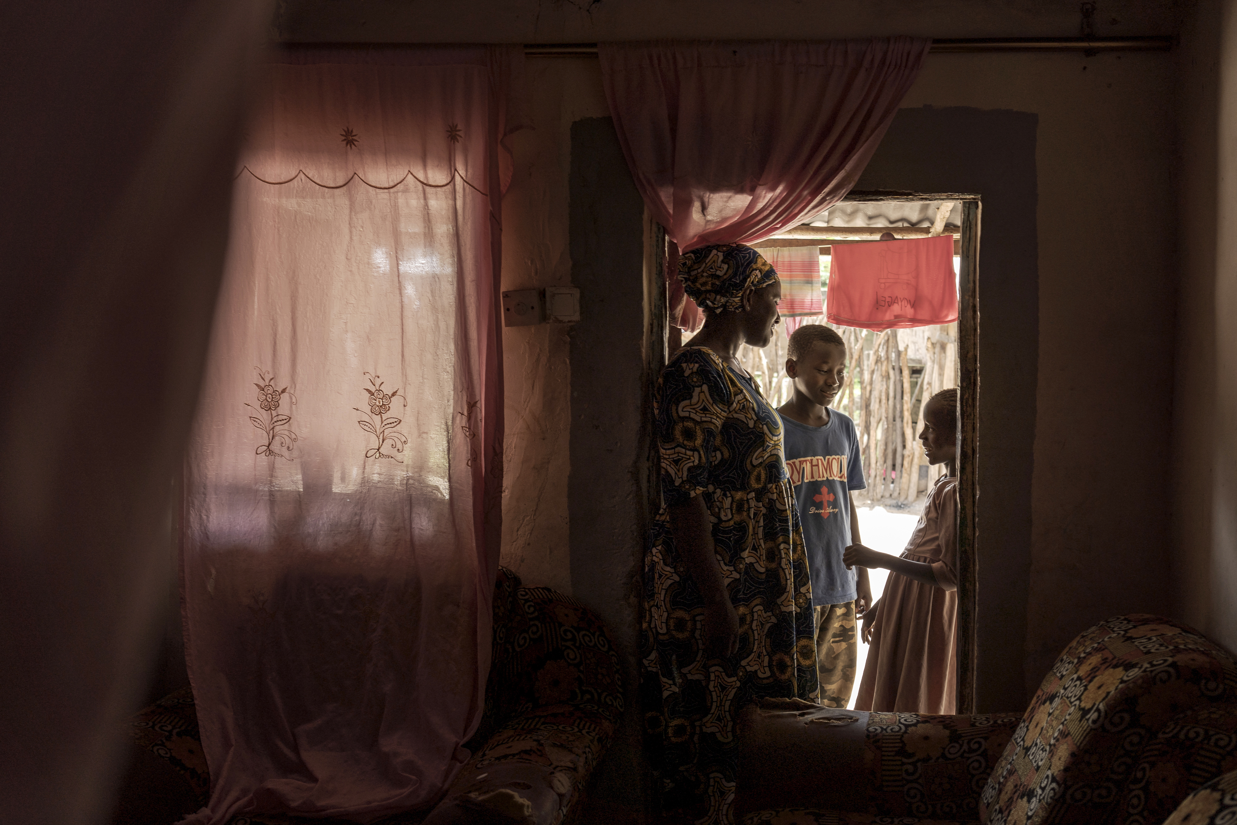 Musukebbe Manjang, left, speaks with her son Boubacar Darbo, center, and his sister Fatima in the village of Kwinella, Gambia, on July 27, 2024. (AP Photo/Annika Hammerschlag)