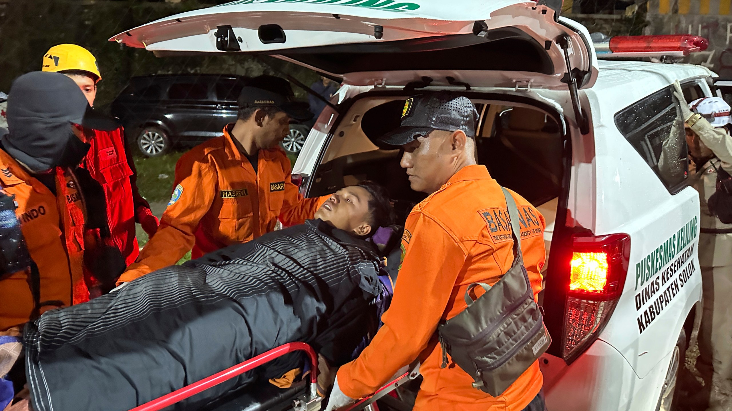 Rescuers transfer a survivor into an ambulance after a landslide set off by torrential rains smashed down into an unauthorized gold mining operation, killing several people, in Solok, West Sumatra, Indonesia, Saturday, Sept. 28, 2024. (AP Photo/John Nedy)