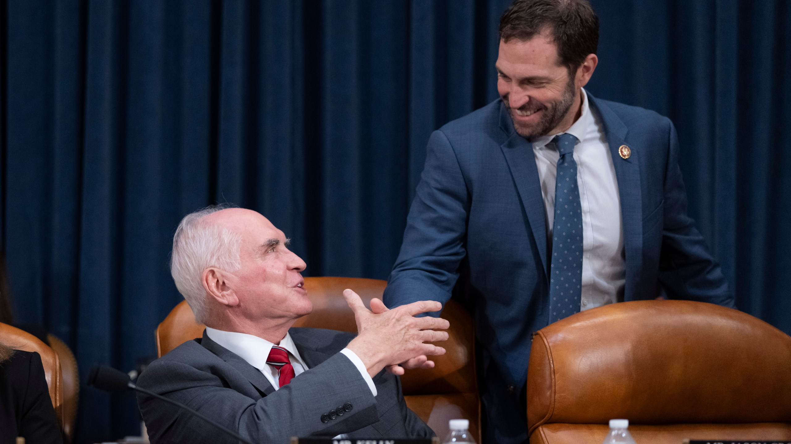 Chairman Rep. Mike Kelly, R-Pa., left, greets Ranking Member Rep. Jason Crow, D-Colo., right, at the first public hearing of a bipartisan congressional task force investigating the assassination attempts against Republican presidential nominee former President Donald Trump, at Capitol Hill in Washington, Thursday, Sept. 26, 2024. (AP Photo/Ben Curtis)