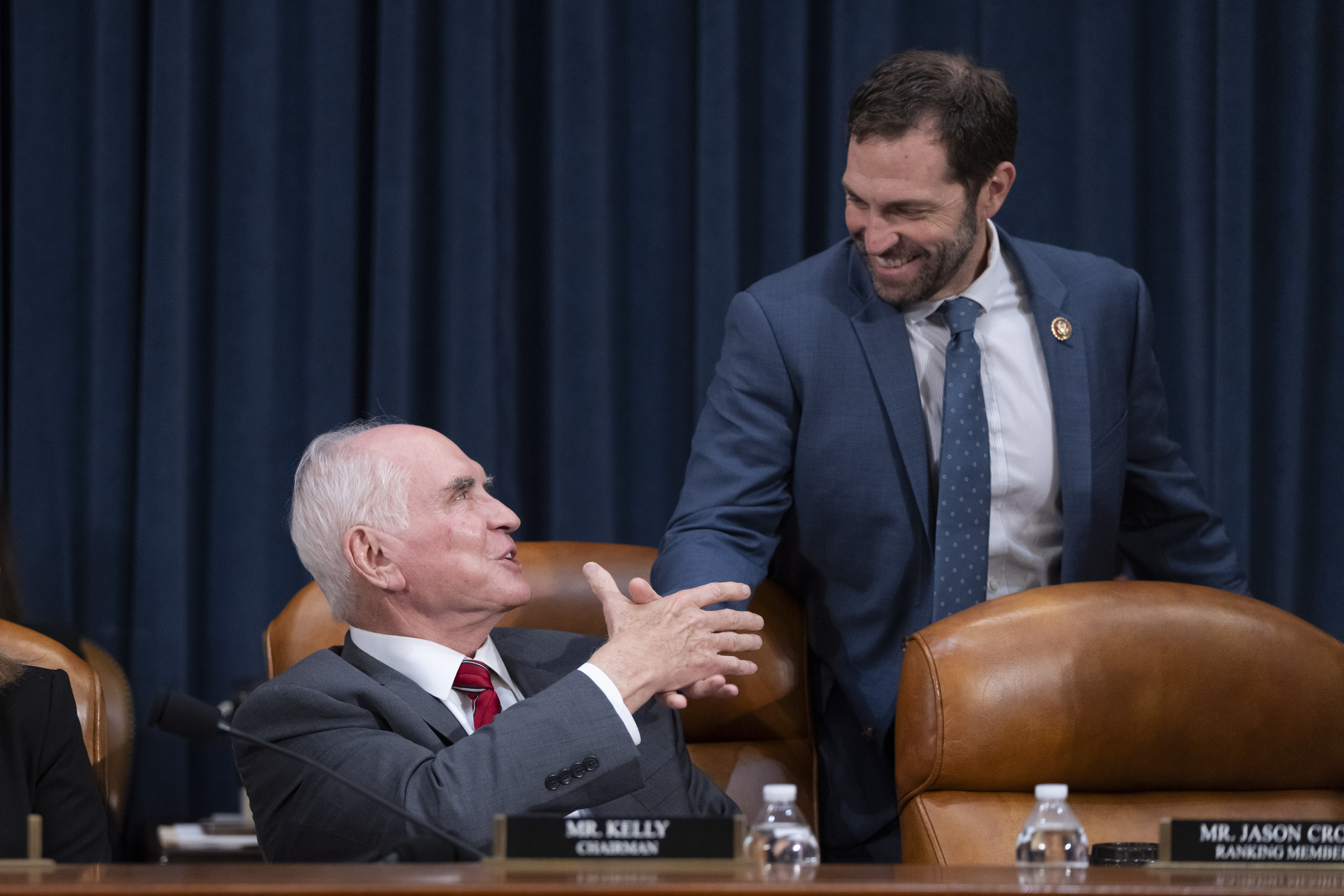 Chairman Rep. Mike Kelly, R-Pa., left, greets Ranking Member Rep. Jason Crow, D-Colo., right, at the first public hearing of a bipartisan congressional task force investigating the assassination attempts against Republican presidential nominee former President Donald Trump, at Capitol Hill in Washington, Thursday, Sept. 26, 2024. (AP Photo/Ben Curtis)