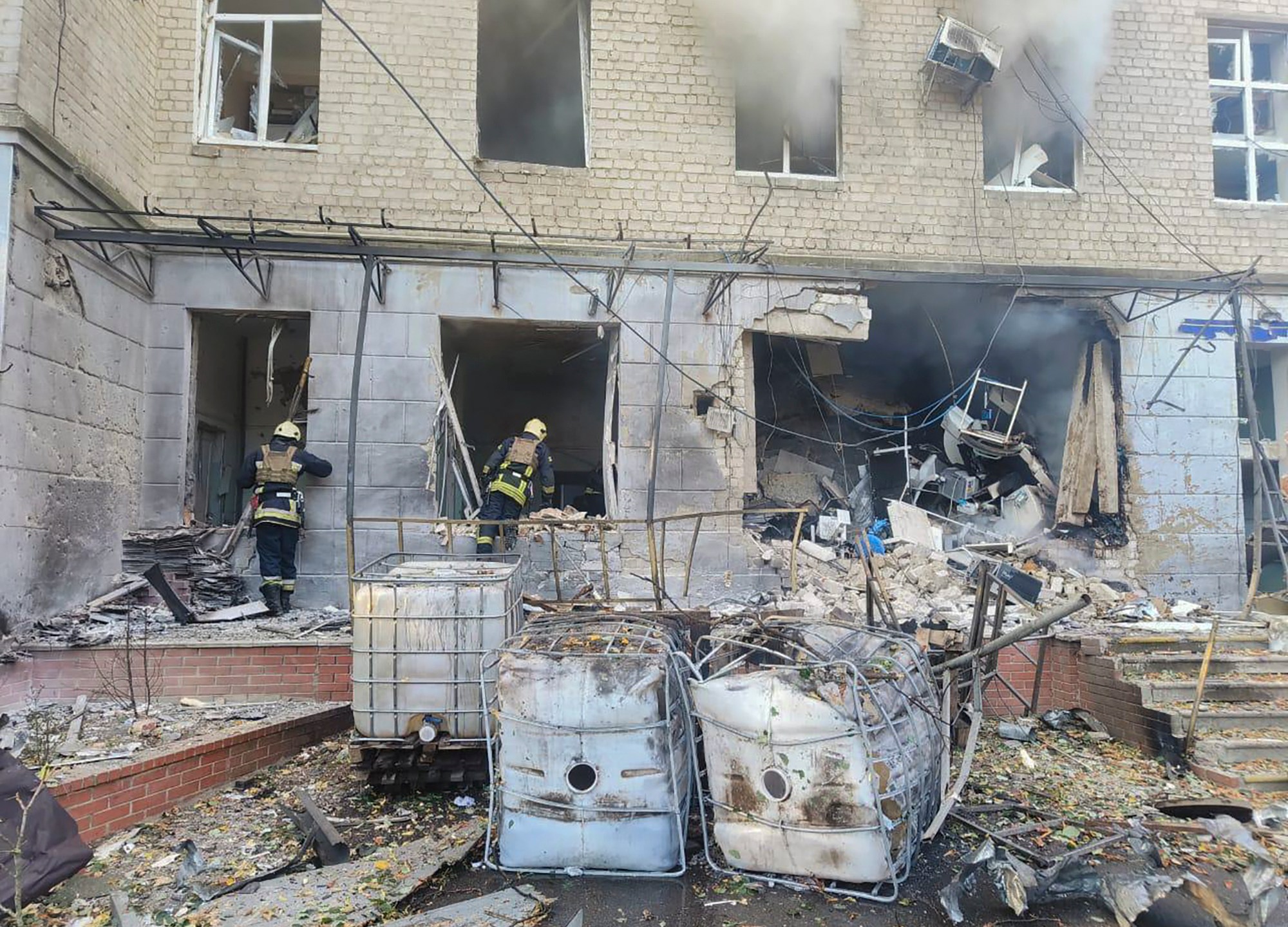 In this photo provided by the Ukrainian Emergency Service, emergency services workers look to move rubble and find injured after Russian attacks on a medical center in the northeastern Ukrainian city of Sumy Saturday, Sept. 28, 2024. (Ukrainian Emergency Service via AP)