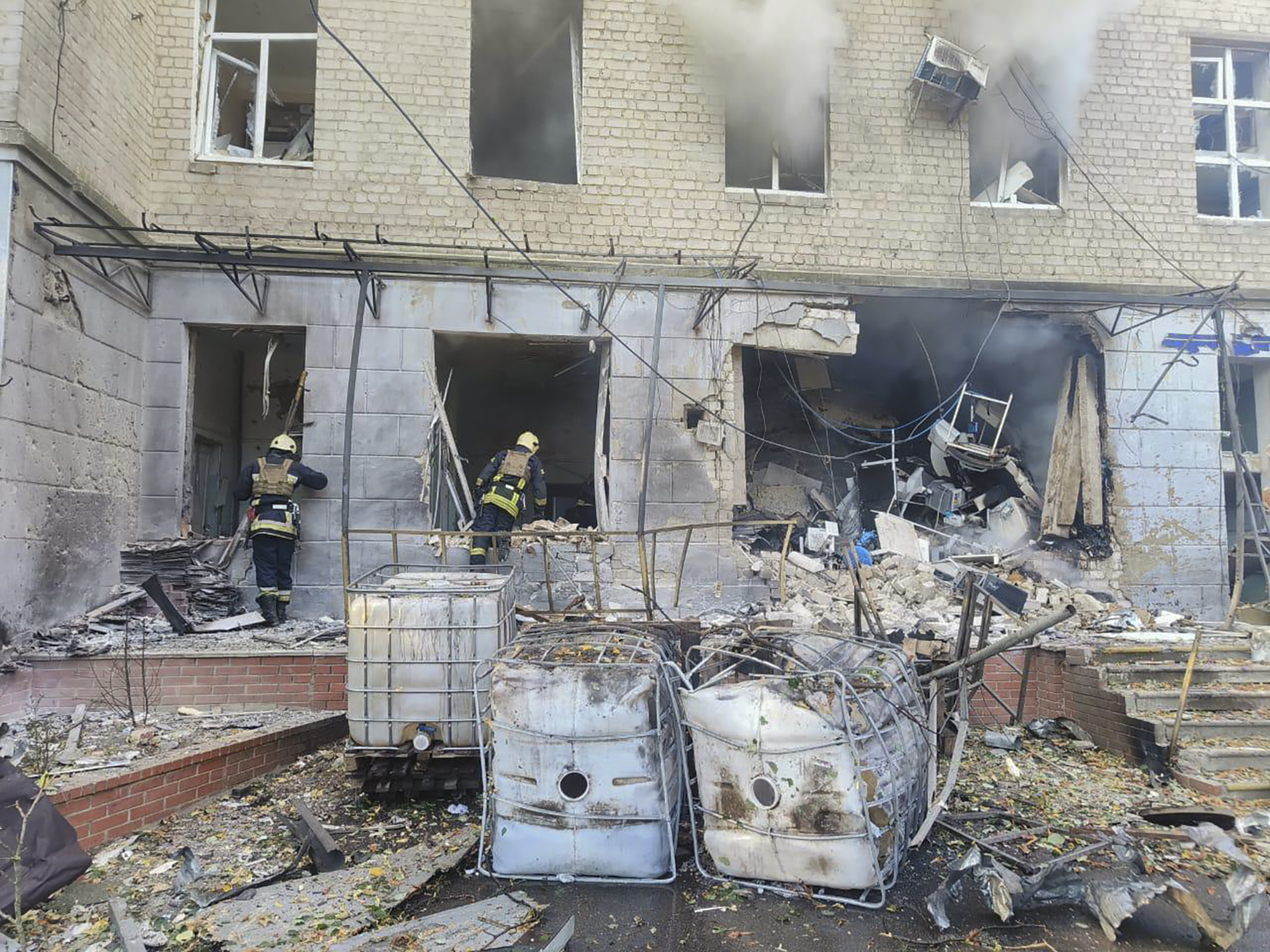 In this photo provided by the Ukrainian Emergency Service, emergency services workers look to move rubble and find injured after Russian attacks on a medical center in the northeastern Ukrainian city of Sumy Saturday, Sept. 28, 2024. (Ukrainian Emergency Service via AP)