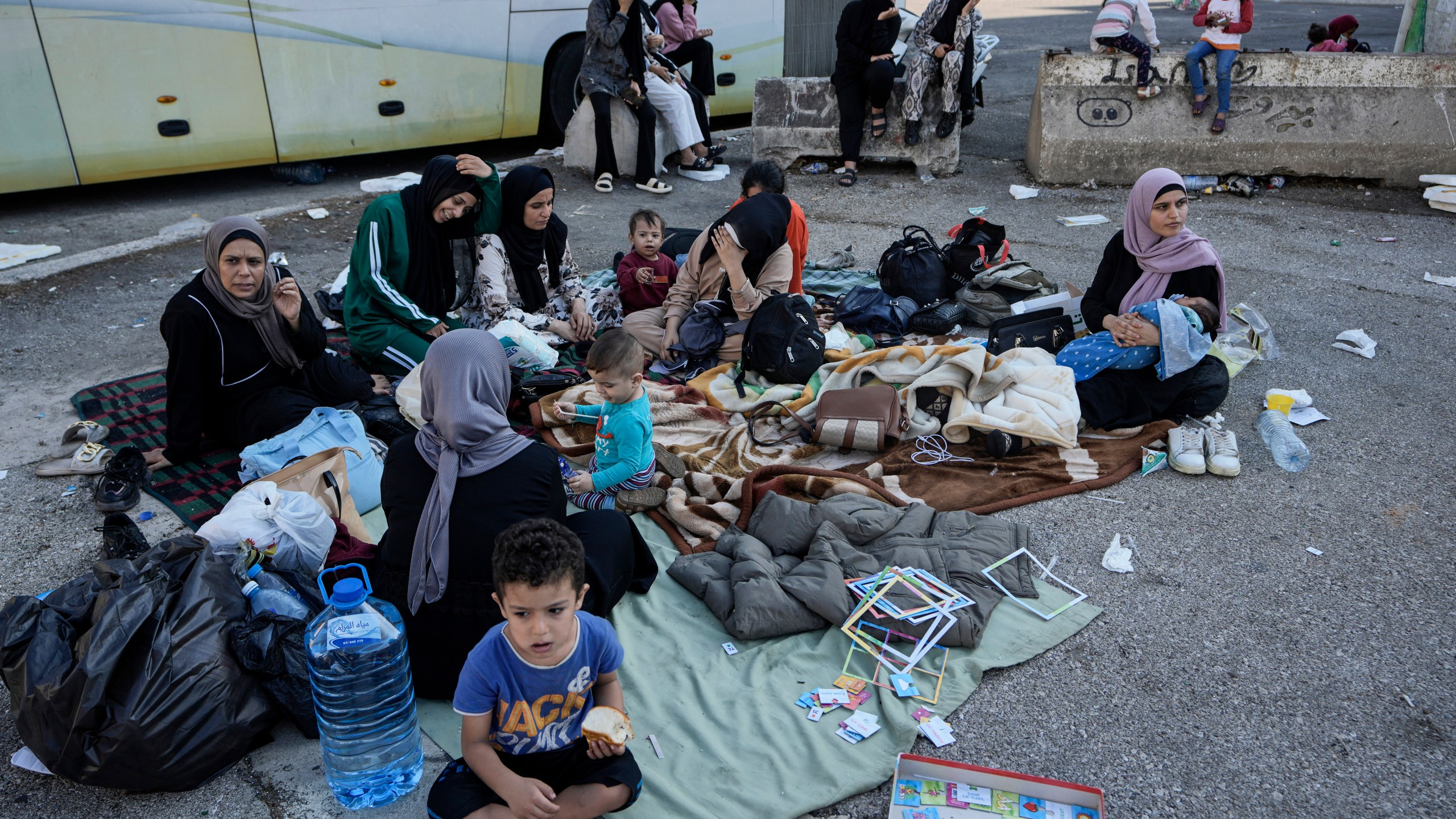 Families sit on the ground in Martyrs' square after fleeing the Israeli airstrikes in Beirut's southern suburbs, Saturday, Sept. 28, 2024. (AP Photo/Bilal Hussein)